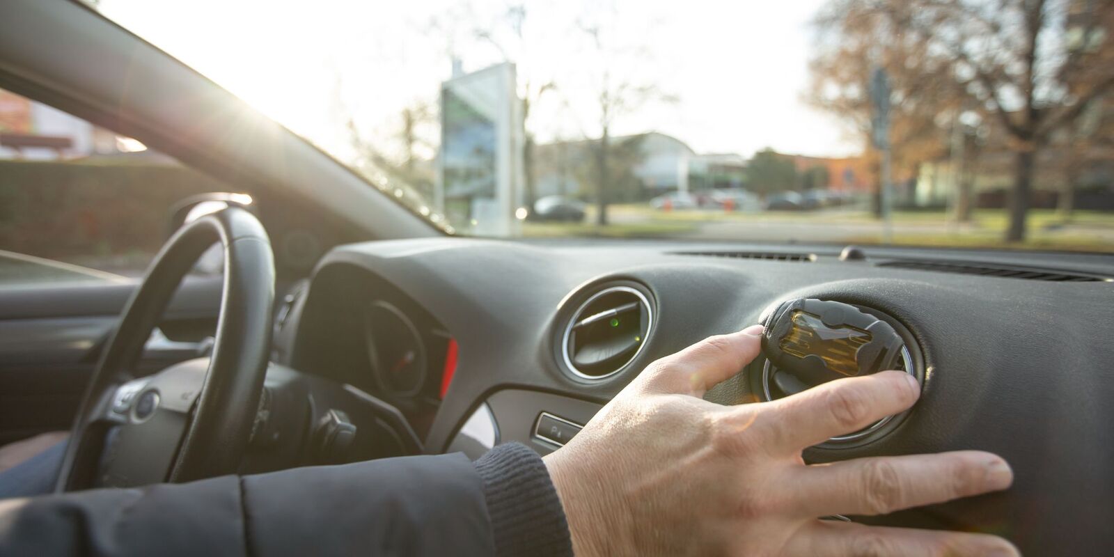 Hand on a car dashboard air vent