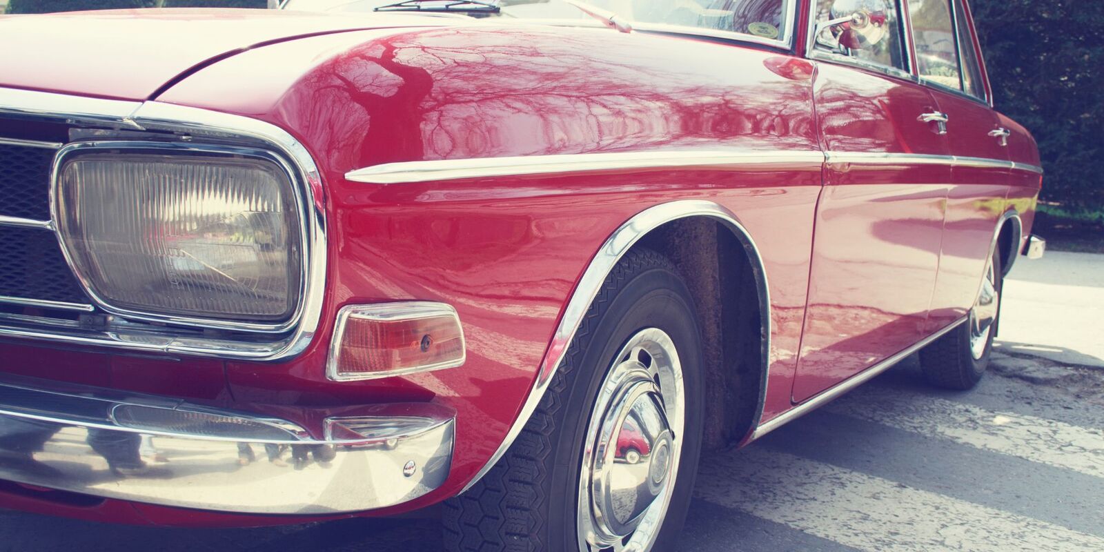 Front of a red classic car in sunlight