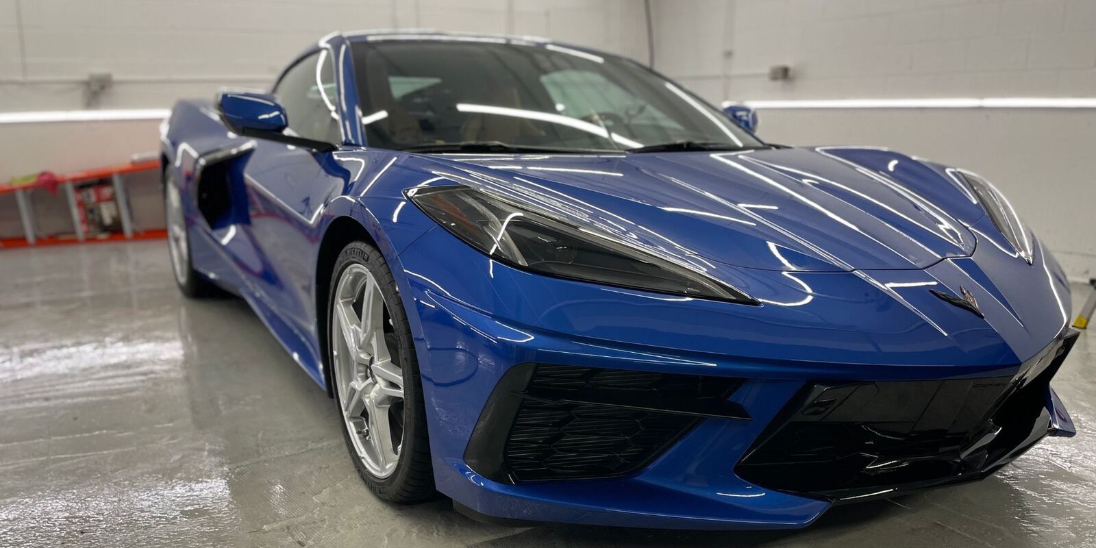 Blue Corvette with a glossy ceramic-coated finish in the studio bay