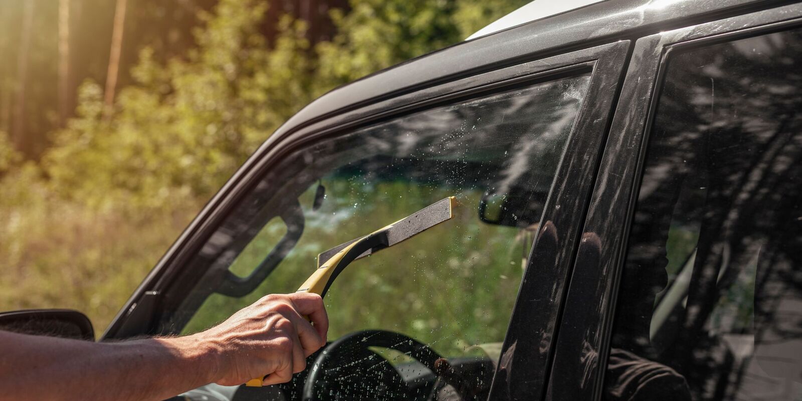 Hand steaming the inside of a car window