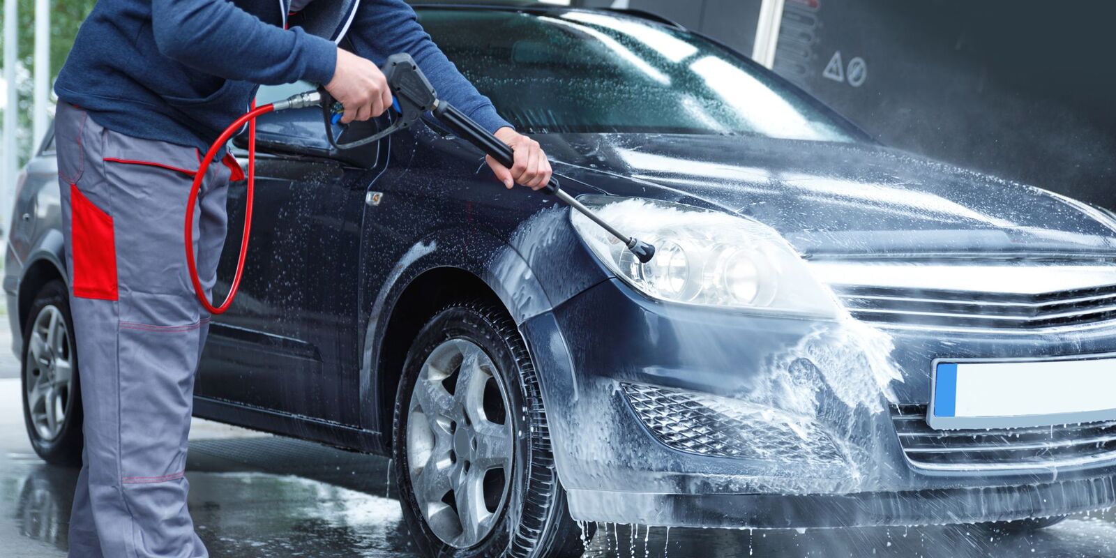Pressure washing a dark gray car