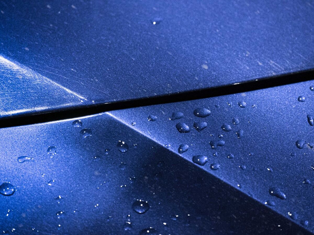 Water beads on a blue coated Range Rover hood