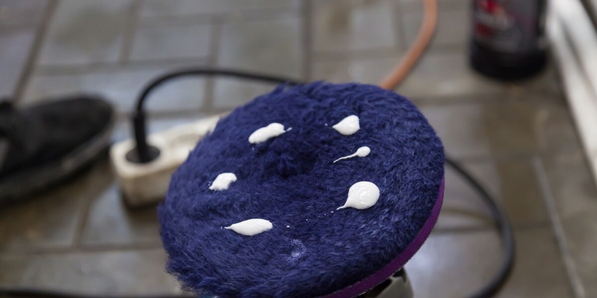 Blue wool polishing pad with compound on a garage floor
