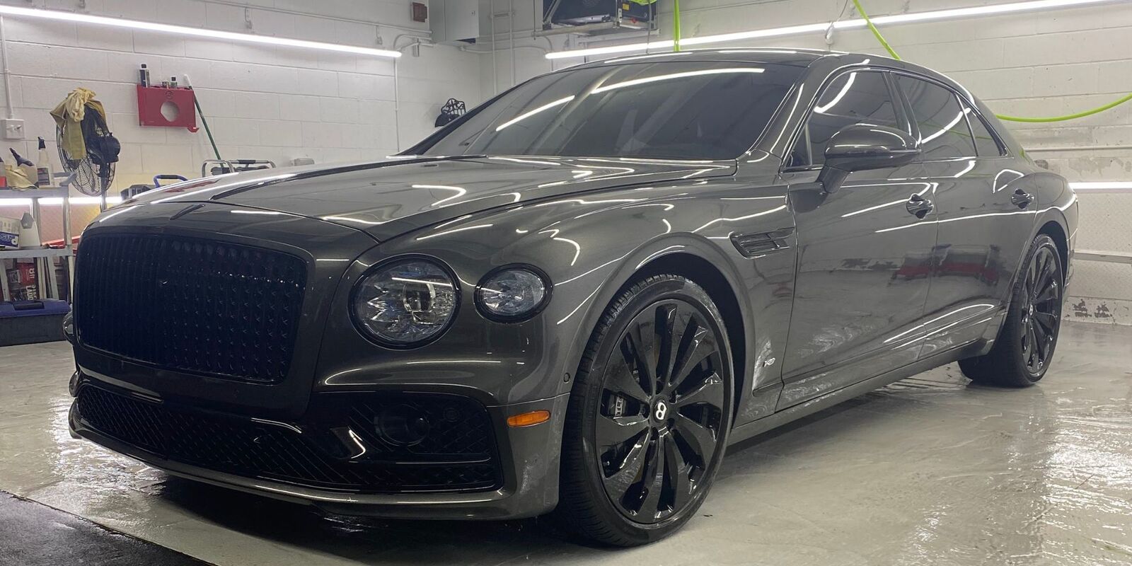 Gray luxury sedan in a white studio bay
