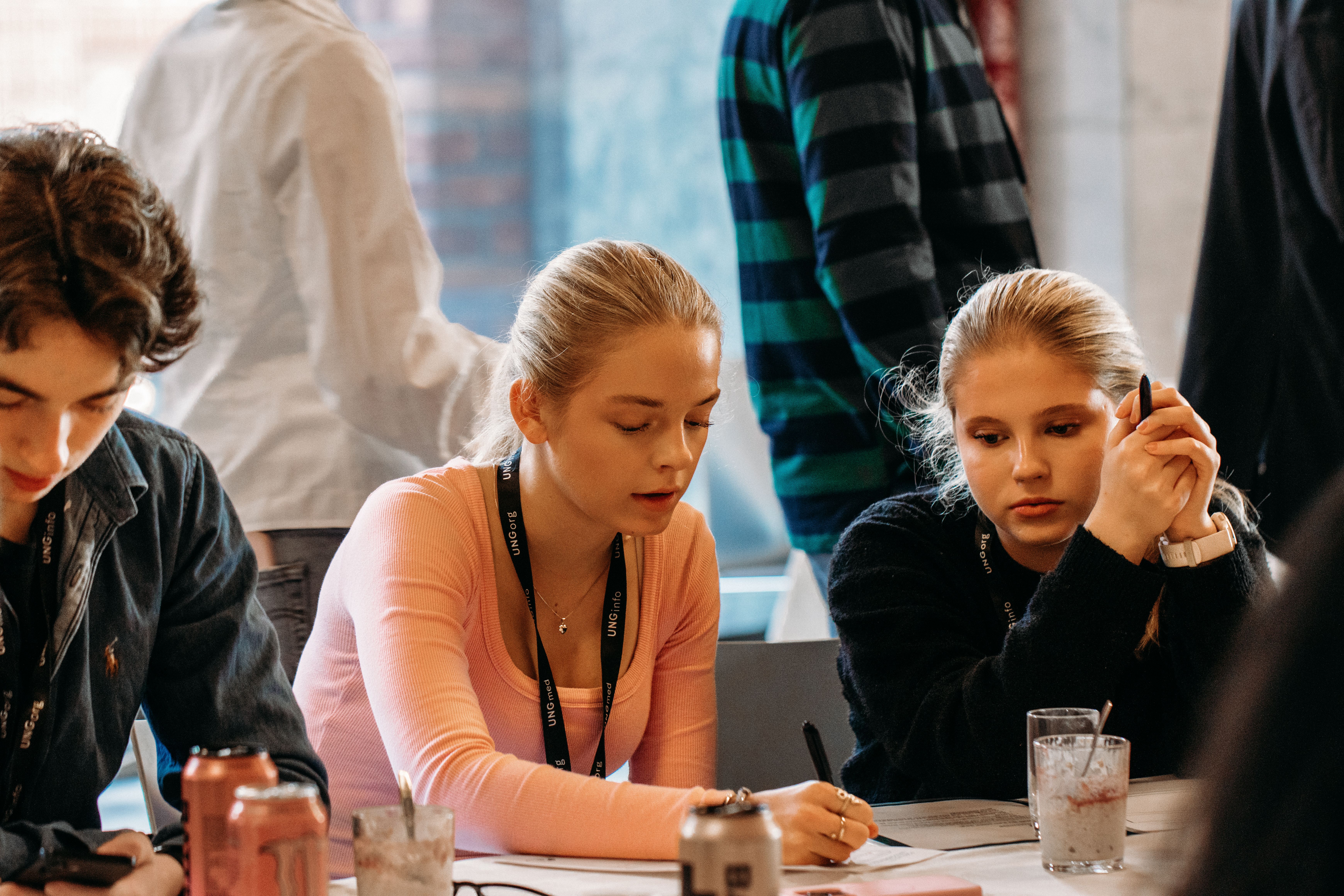 To jenter sitter skriver ned forslag til en politisk sak