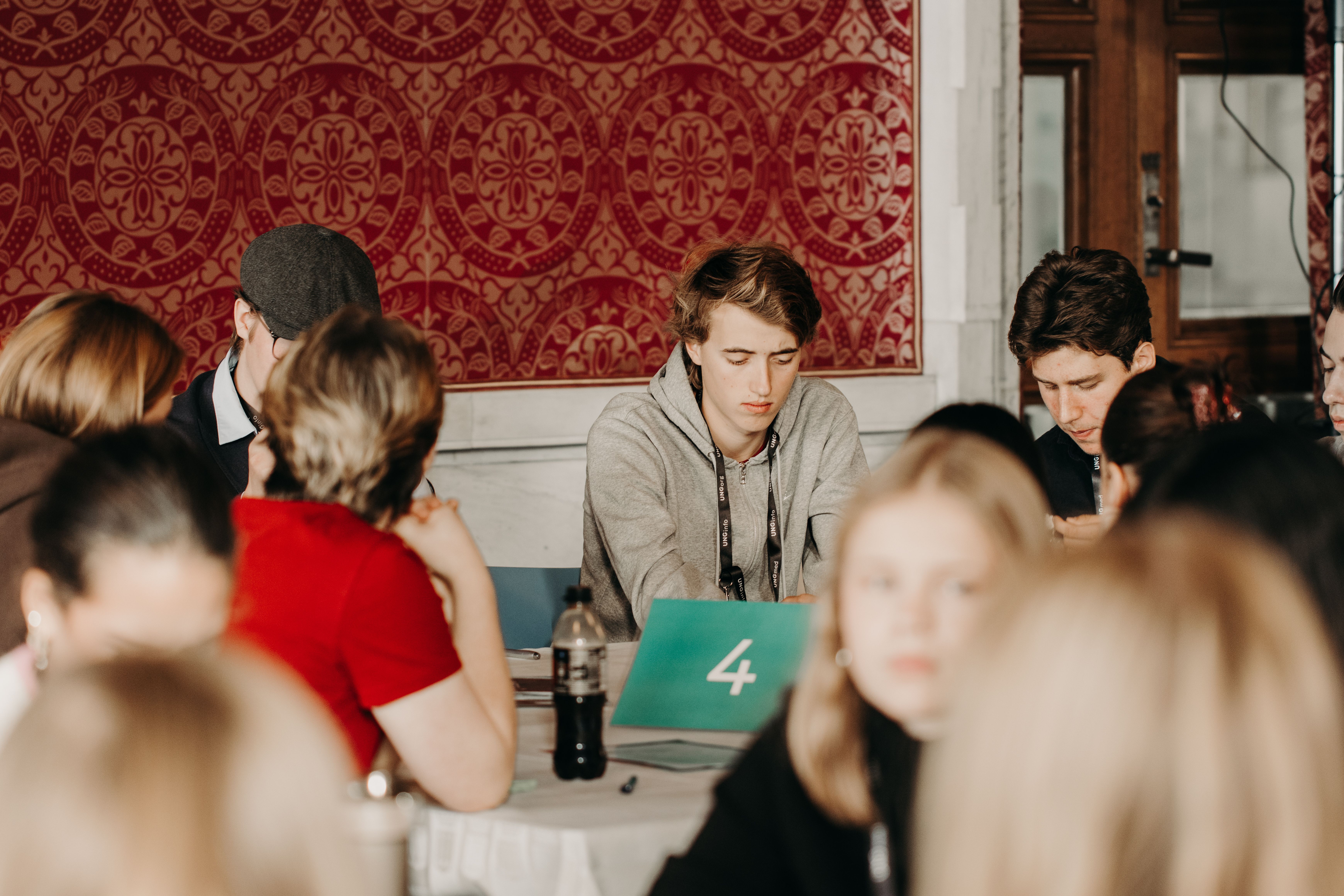 Ungdommene er fordelt over flere bord hvor alle sitter å skriver eller diskuterer politiske saker
