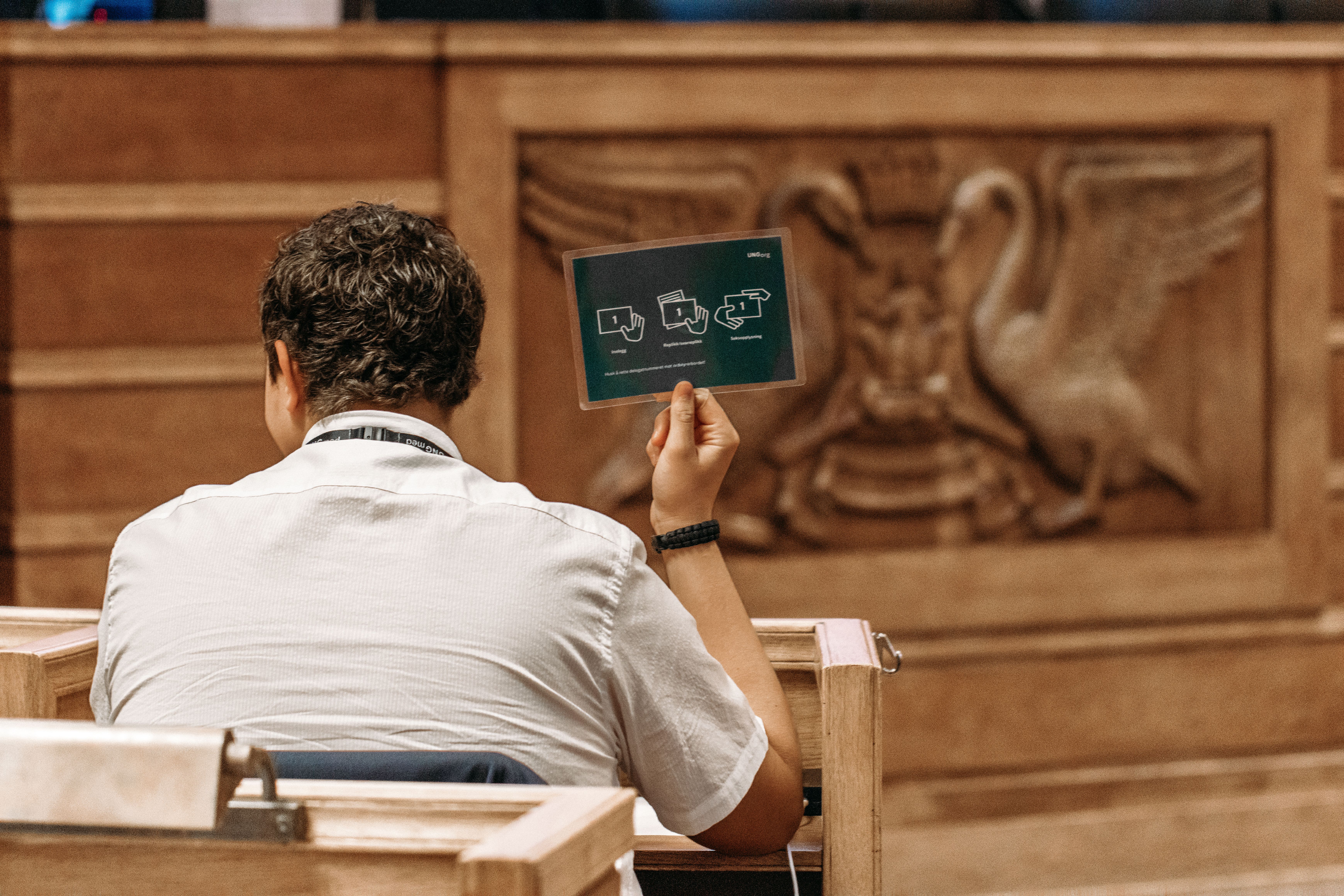 En av guttene holder opp et delegatskilt