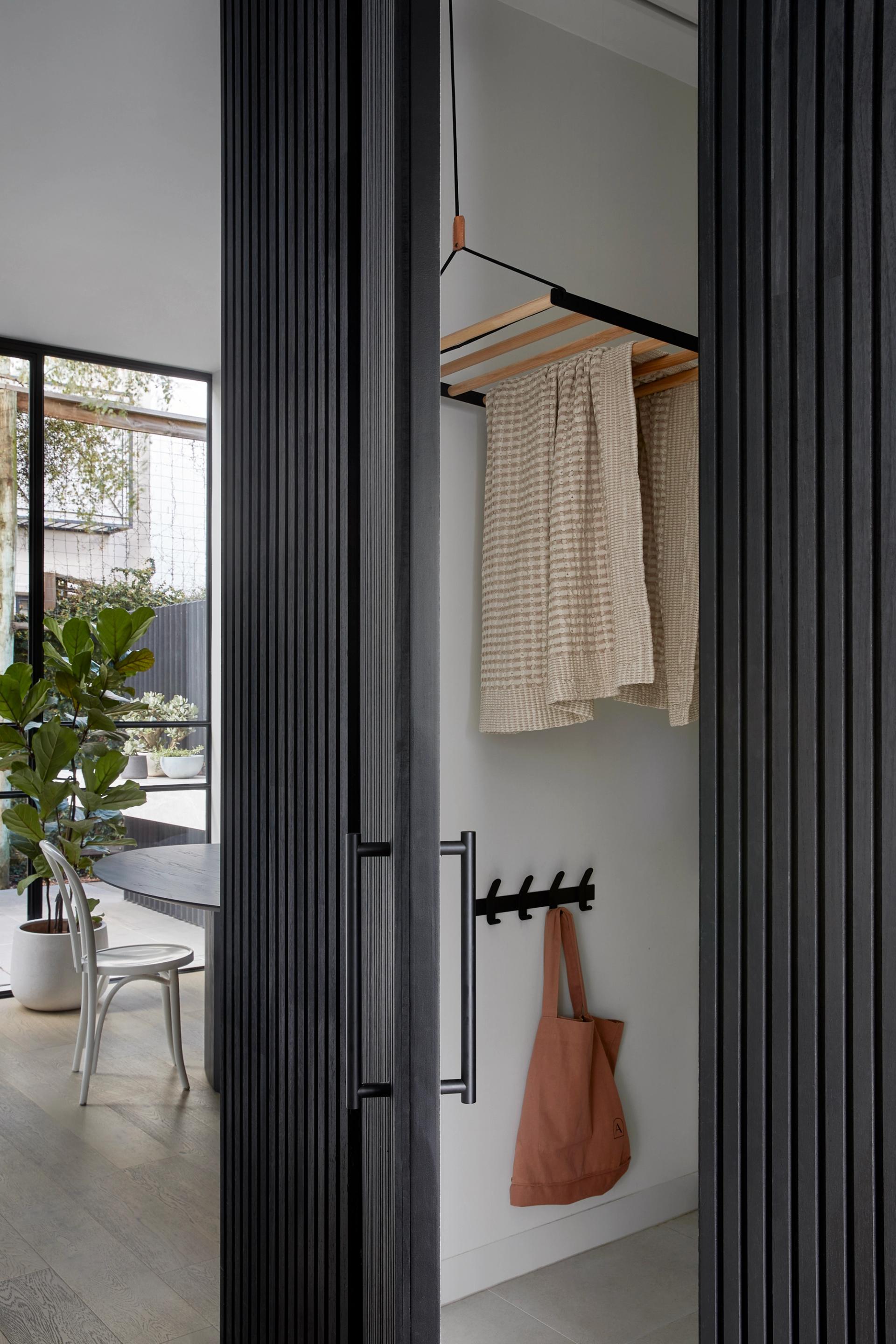 A compact laundry is integrated alongside the kitchen in this South Yarra renovation.