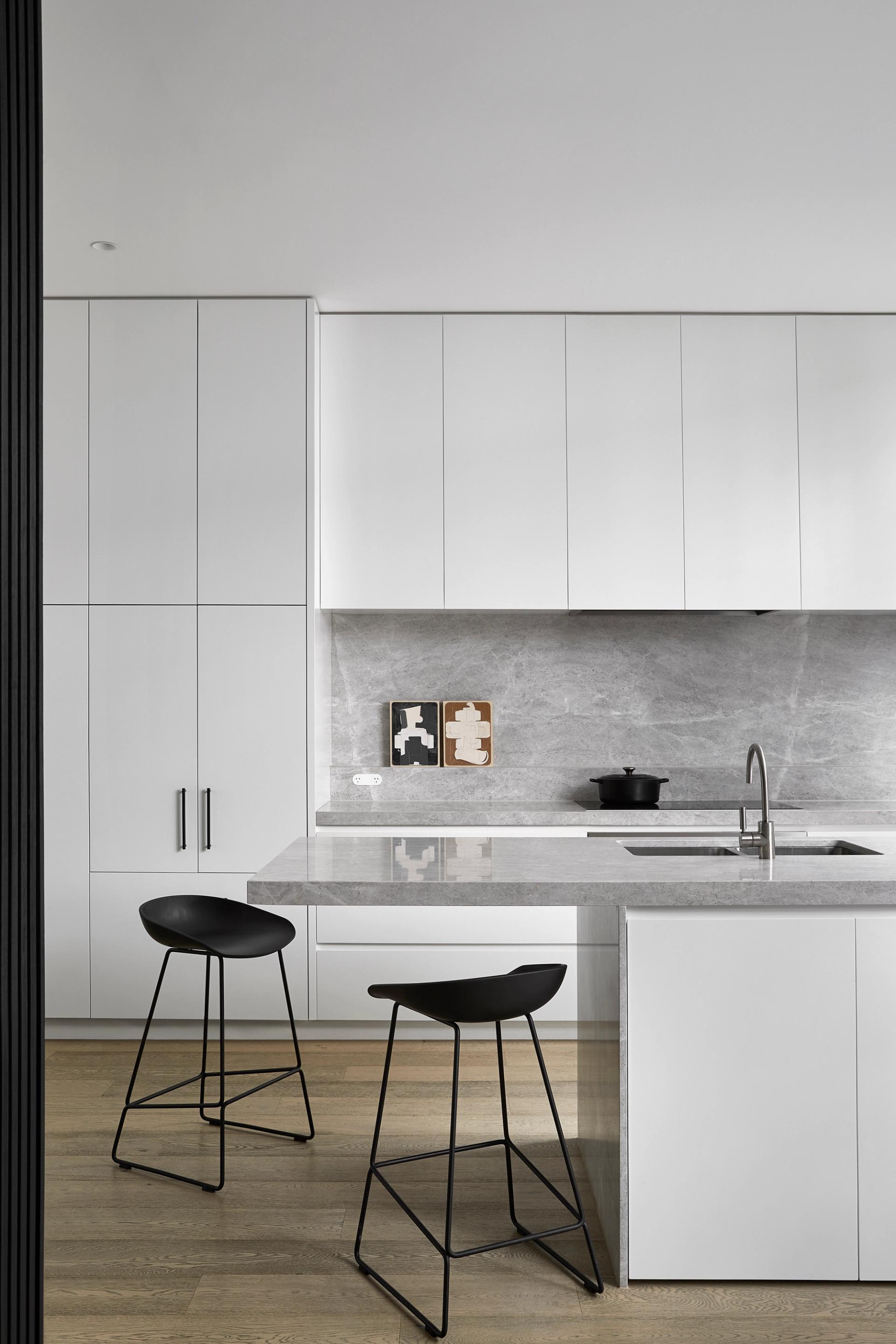 Matching surfaces connect the kitchen and dining spaces to the external courtyard.