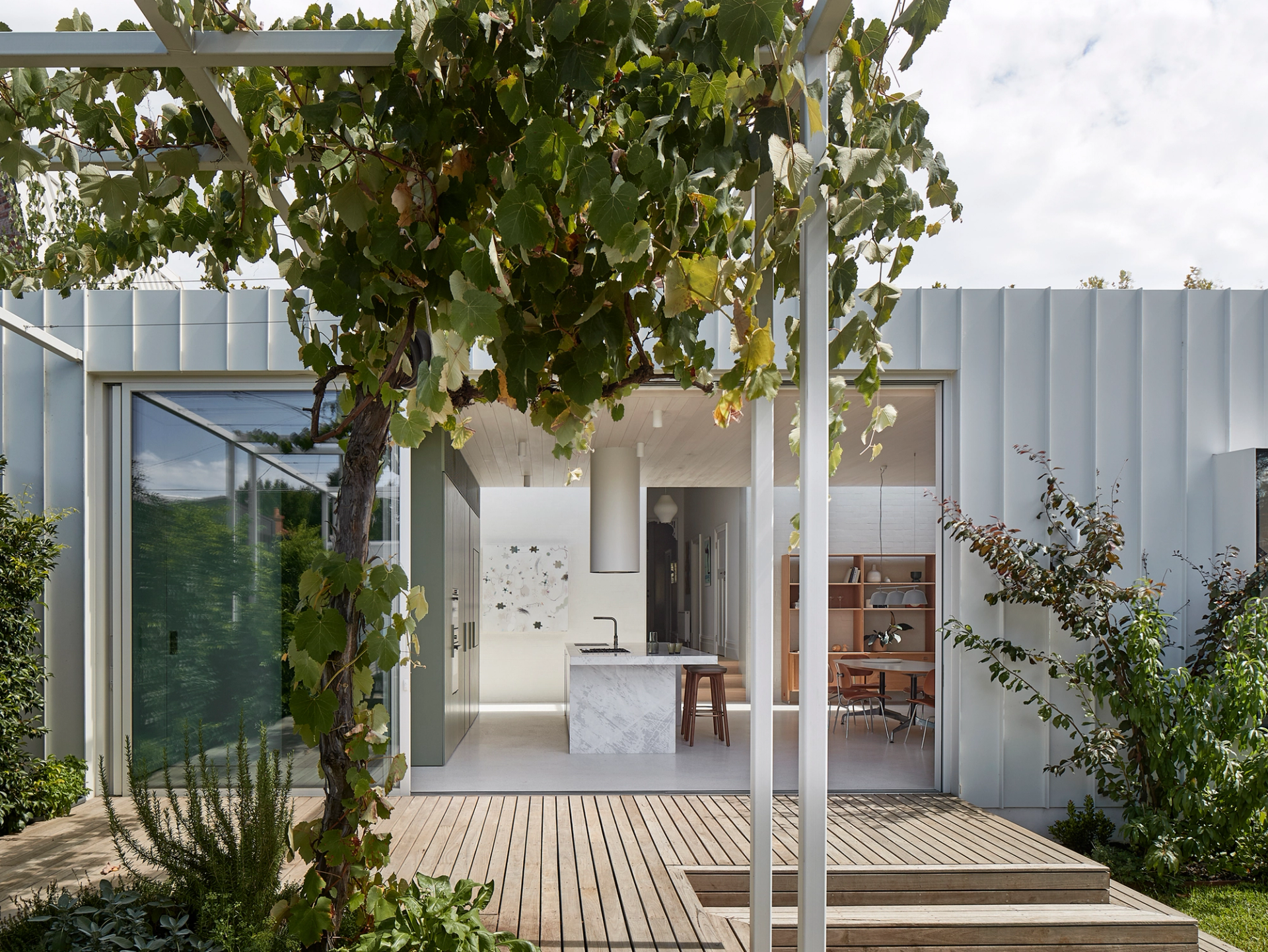 A steel pergola defines a generous outdoor entertaining area directly off the kitchen.