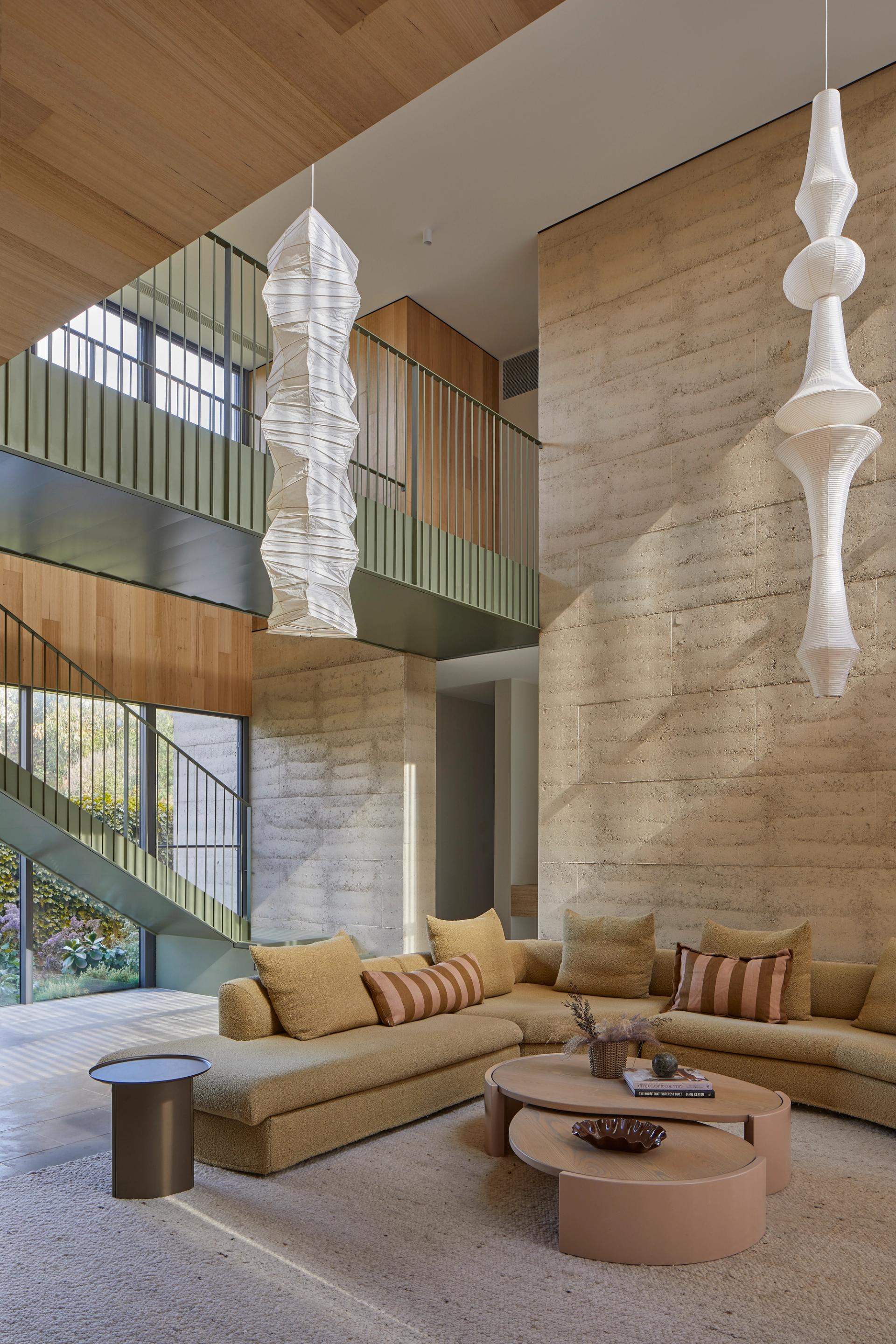 Double height living space at Barwon Dunes House with bridge linking upper level spaces.