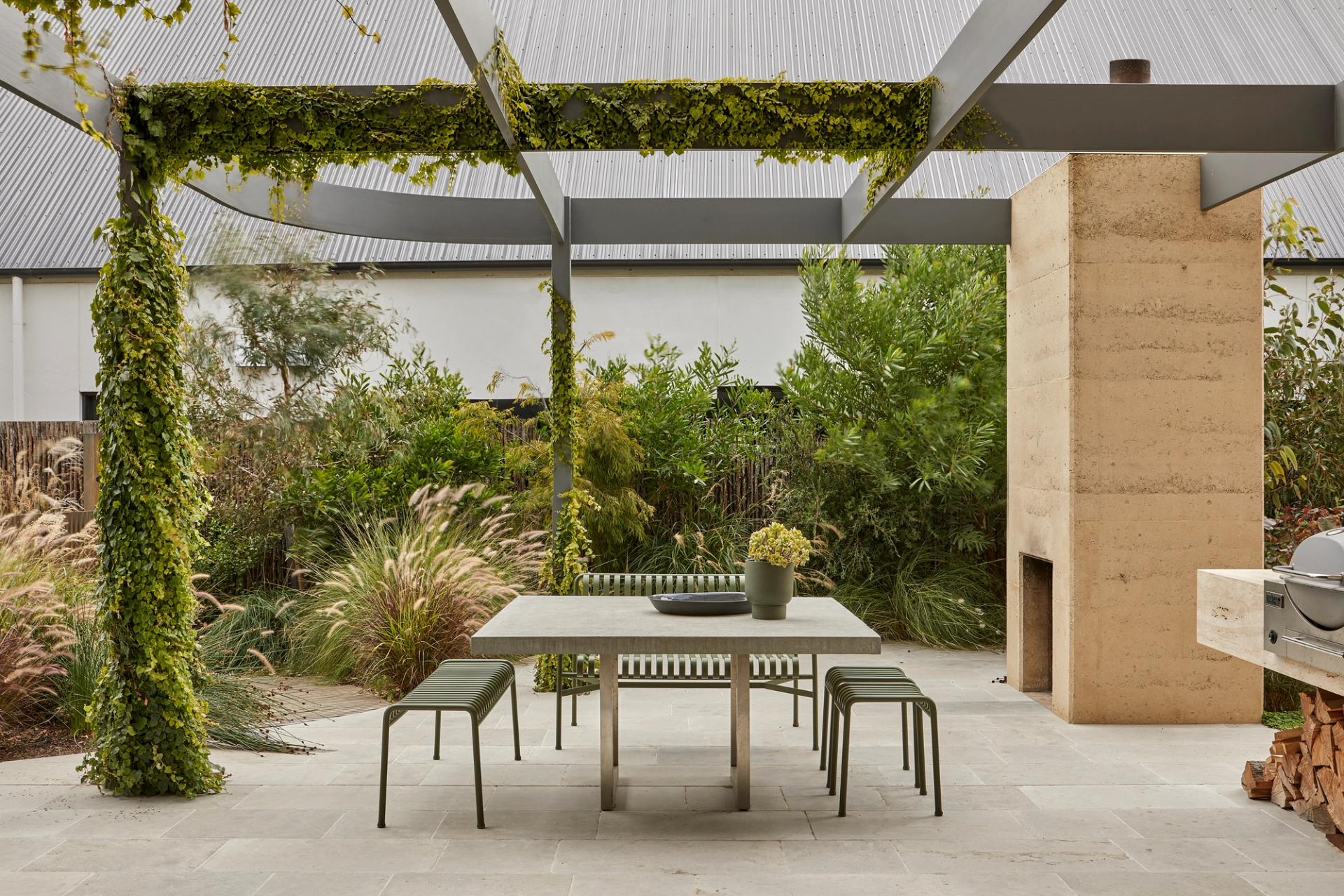 The outdoor terrace at Barwon Dunes House with curved pergola, outdoor fireplace and native garden.