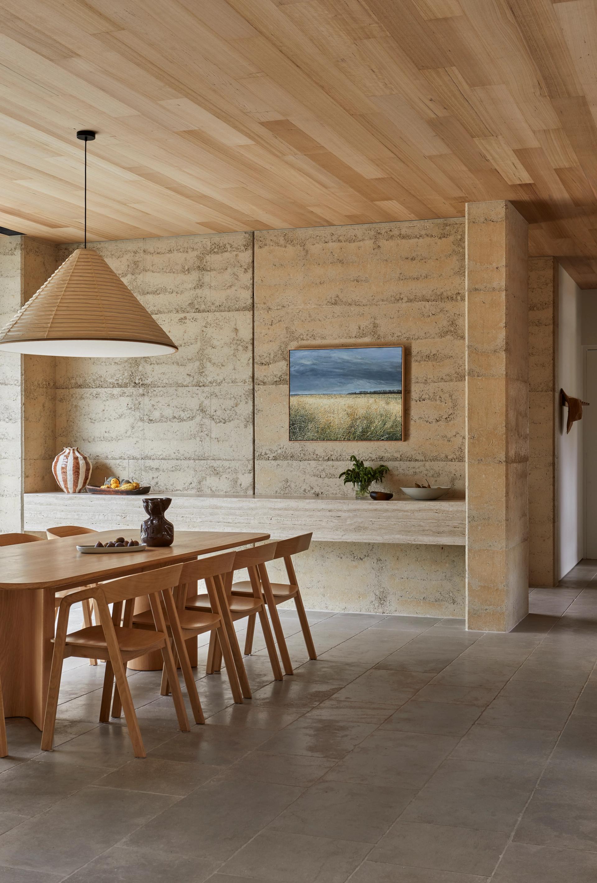 Dining room with timber lined ceiling, limestone flooring and custom timber furniture