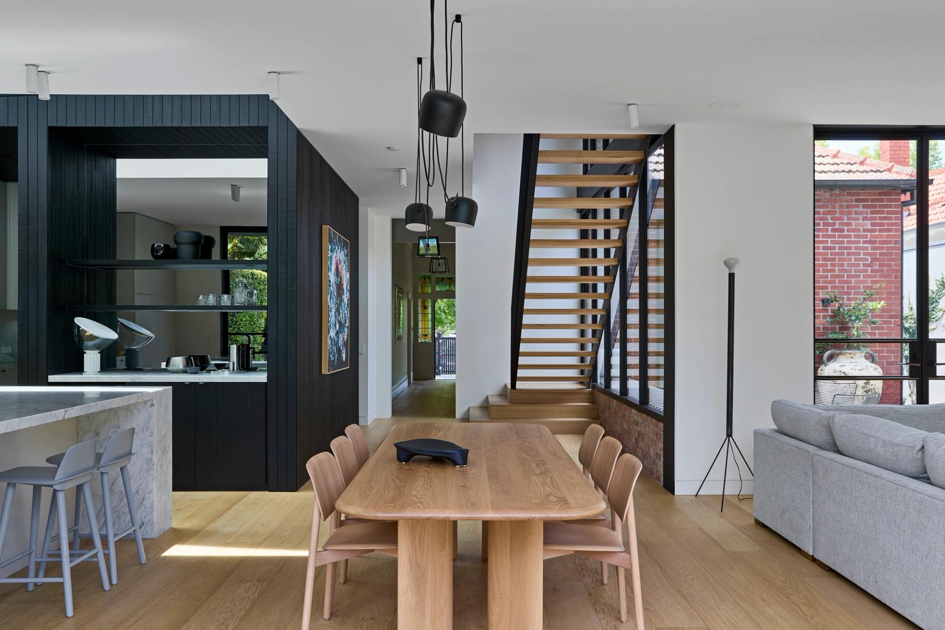 The bold stair and adjacent walkway link a retained loft space to the new upper-level addition.