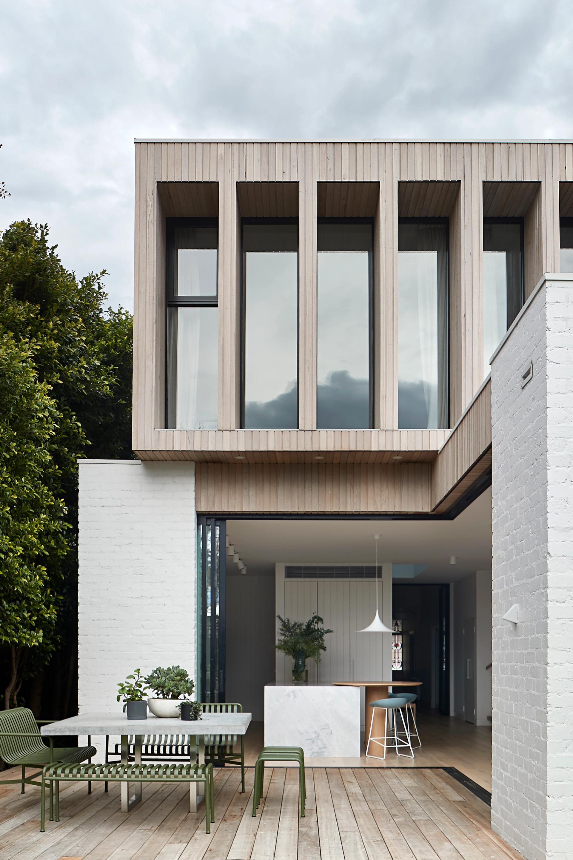 White bricks and limed timber linear wall panelling adds to the home's breezy atmosphere.