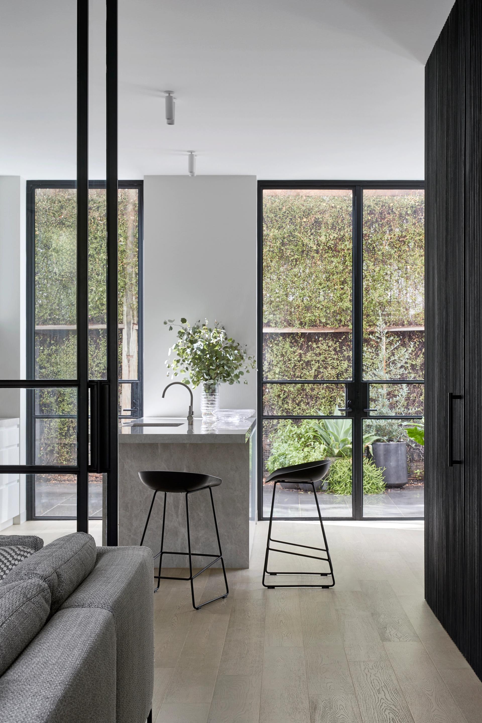 Floor-to-ceiling operable windows at the kitchen flow into the courtyard.