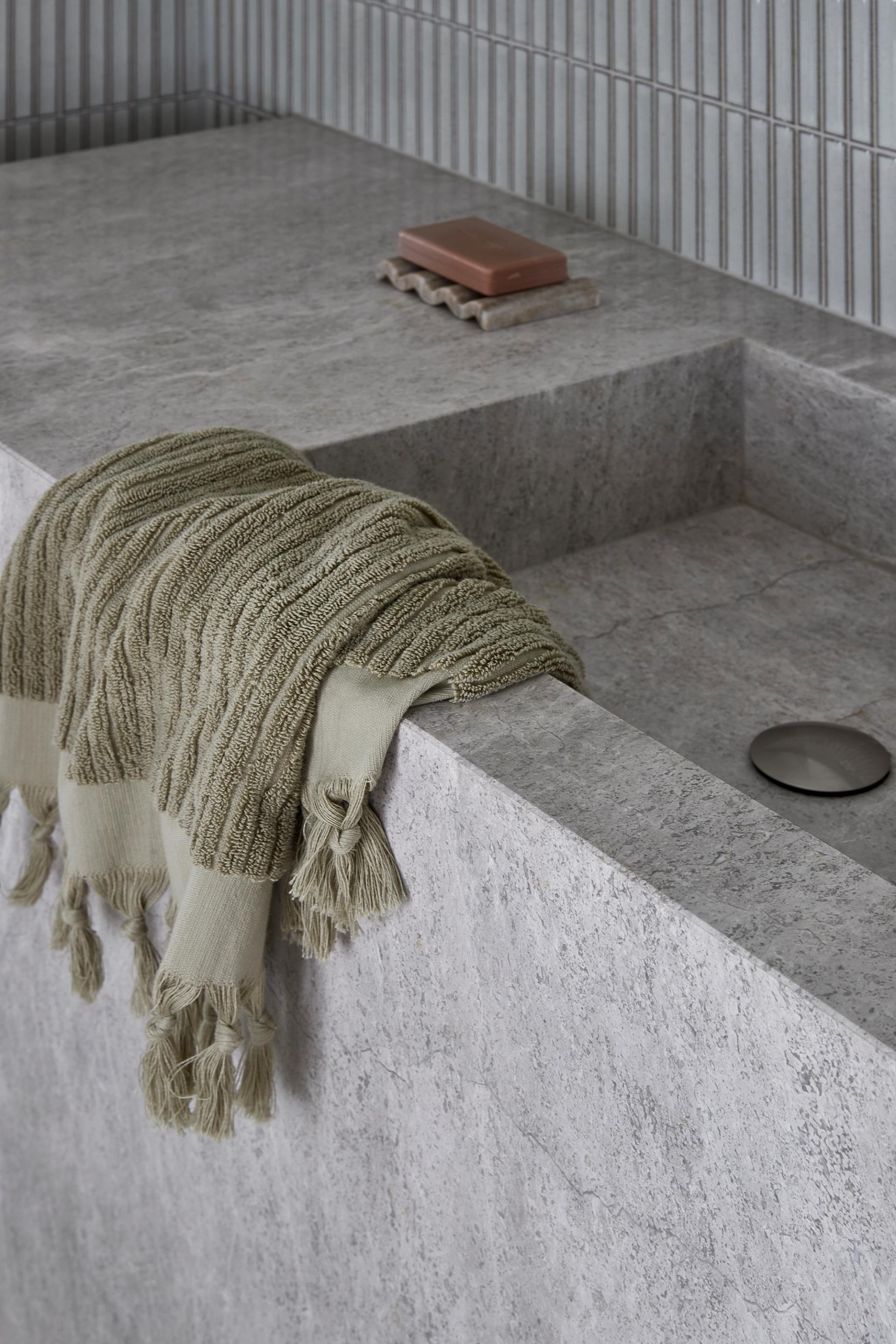 Close-up of the custom stone vanity in the South Yarra Townhouse bathroom featuring an integrated basin and textured ceramic tile splashback.