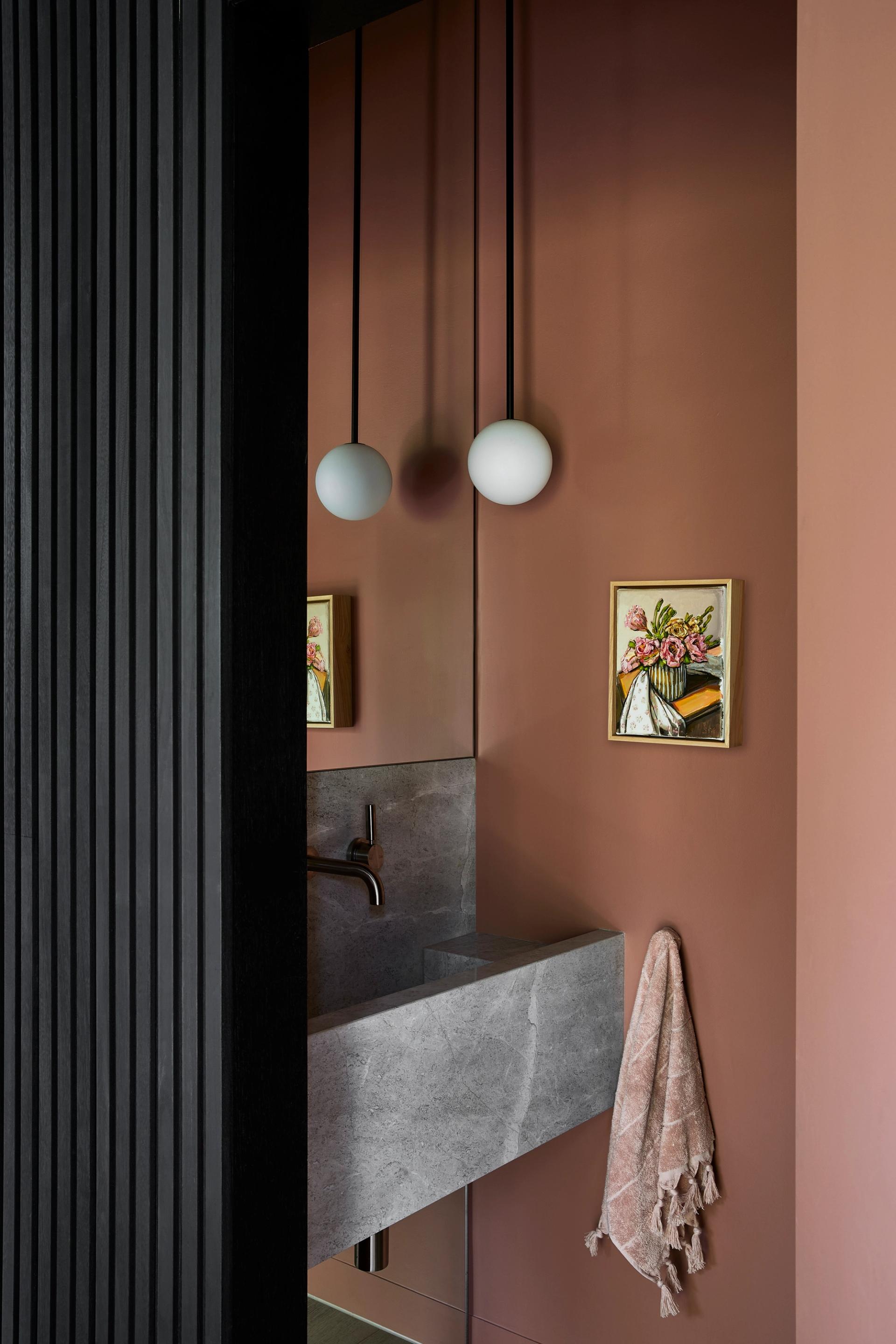 A powder room is concealed beneath the stairs at this South Yarra home.