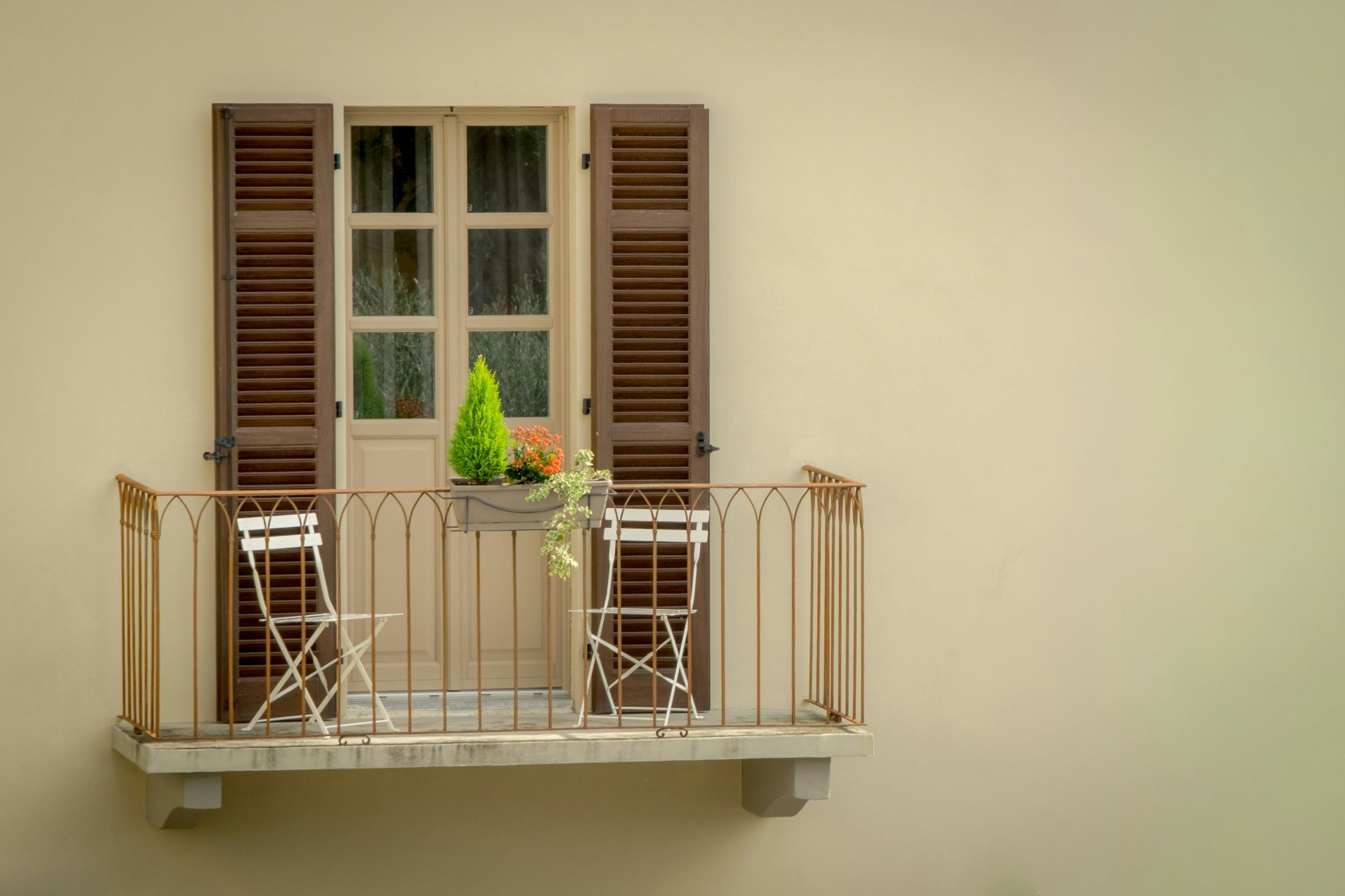 Italian façade with wooden shutters and a small balcony.