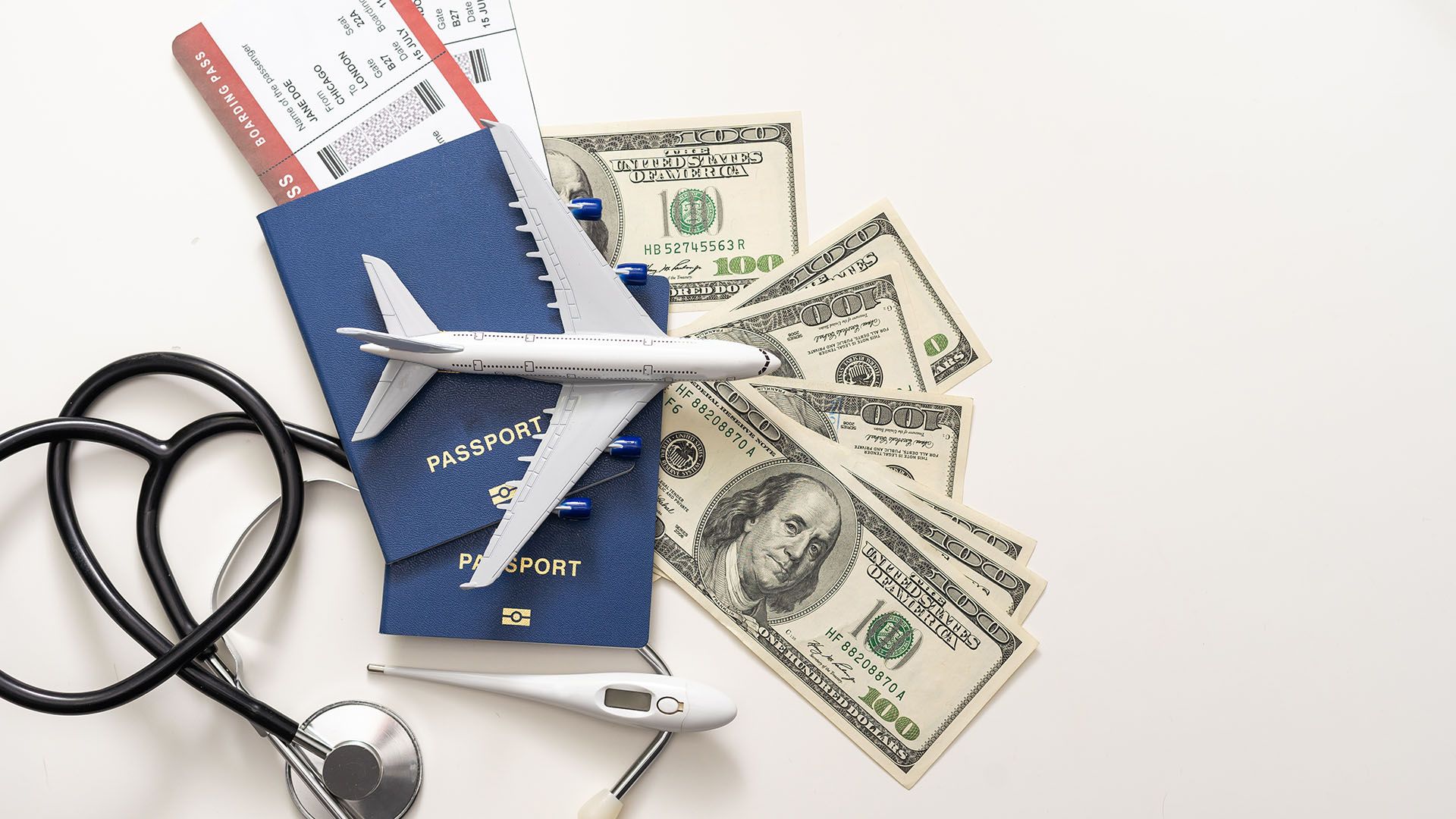 Reisepass mit Geld und einem Stethoskop