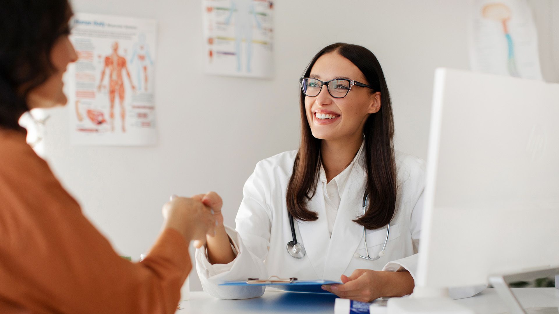 Ärztin gibt Patientin die Hand.