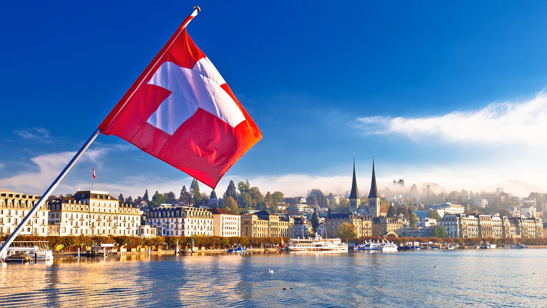Luzerner See und Stadt mit Schweizer Flagge.