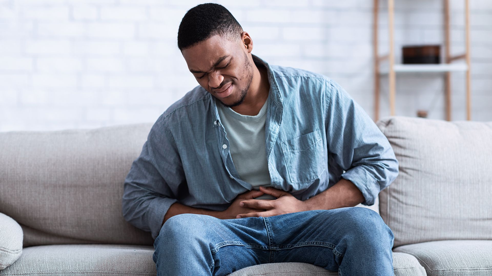 Mann mit Hand auf dem Bauch. Magenkrämpfe, Gastritis