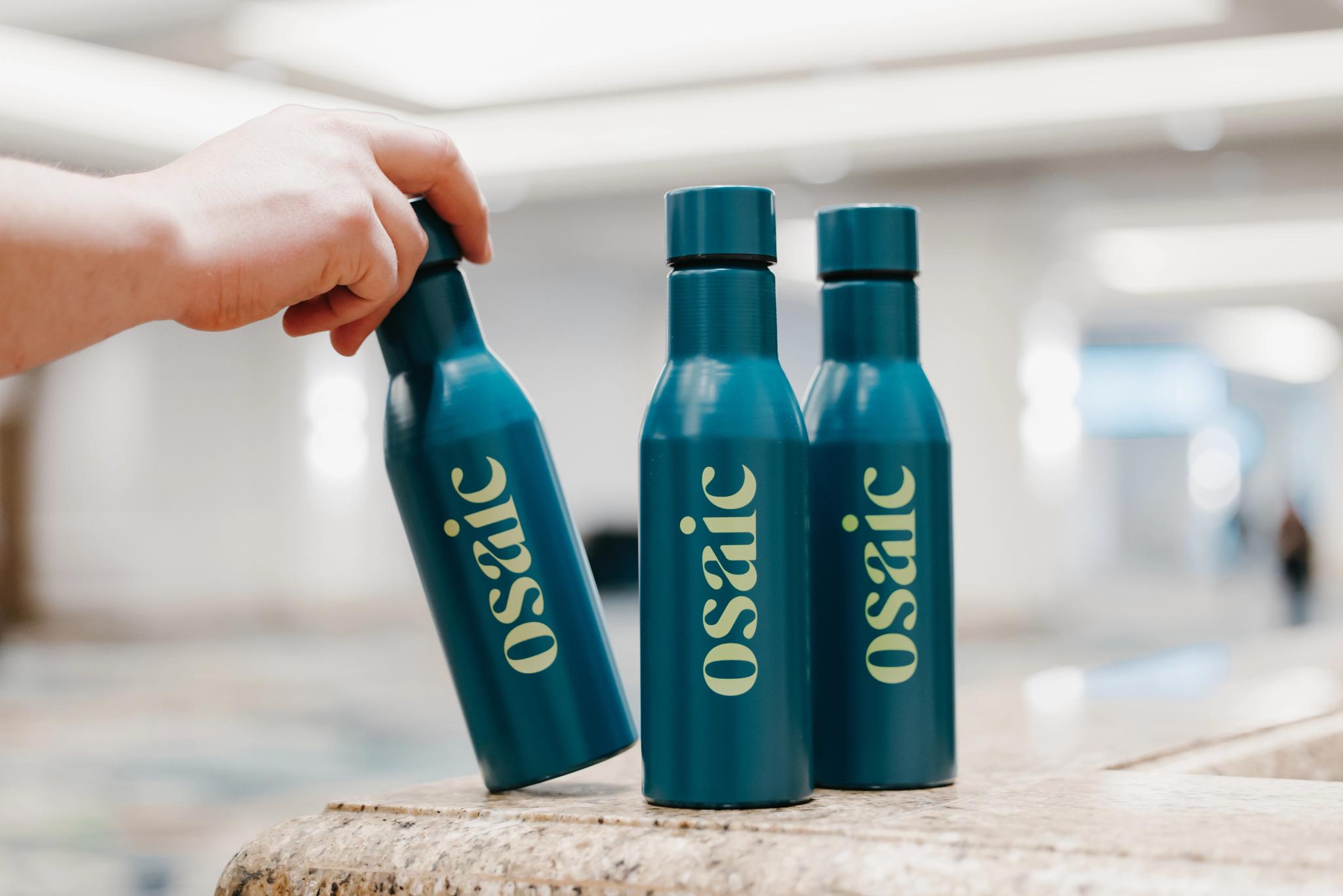 A Financial Professional reaches for an Osaic branded water bottle