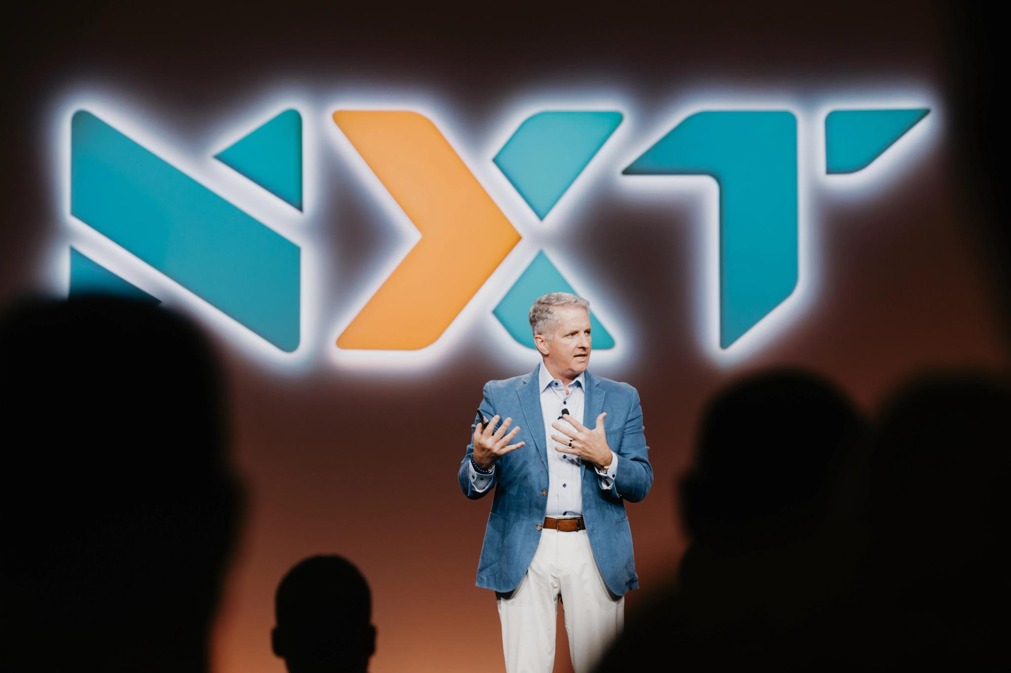 Osaic CEO Jamie Price stands onstage at NXT