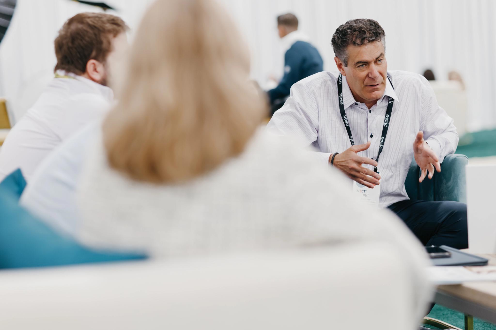 In a casual setting, Phil Blancato speaks to a group of advisors