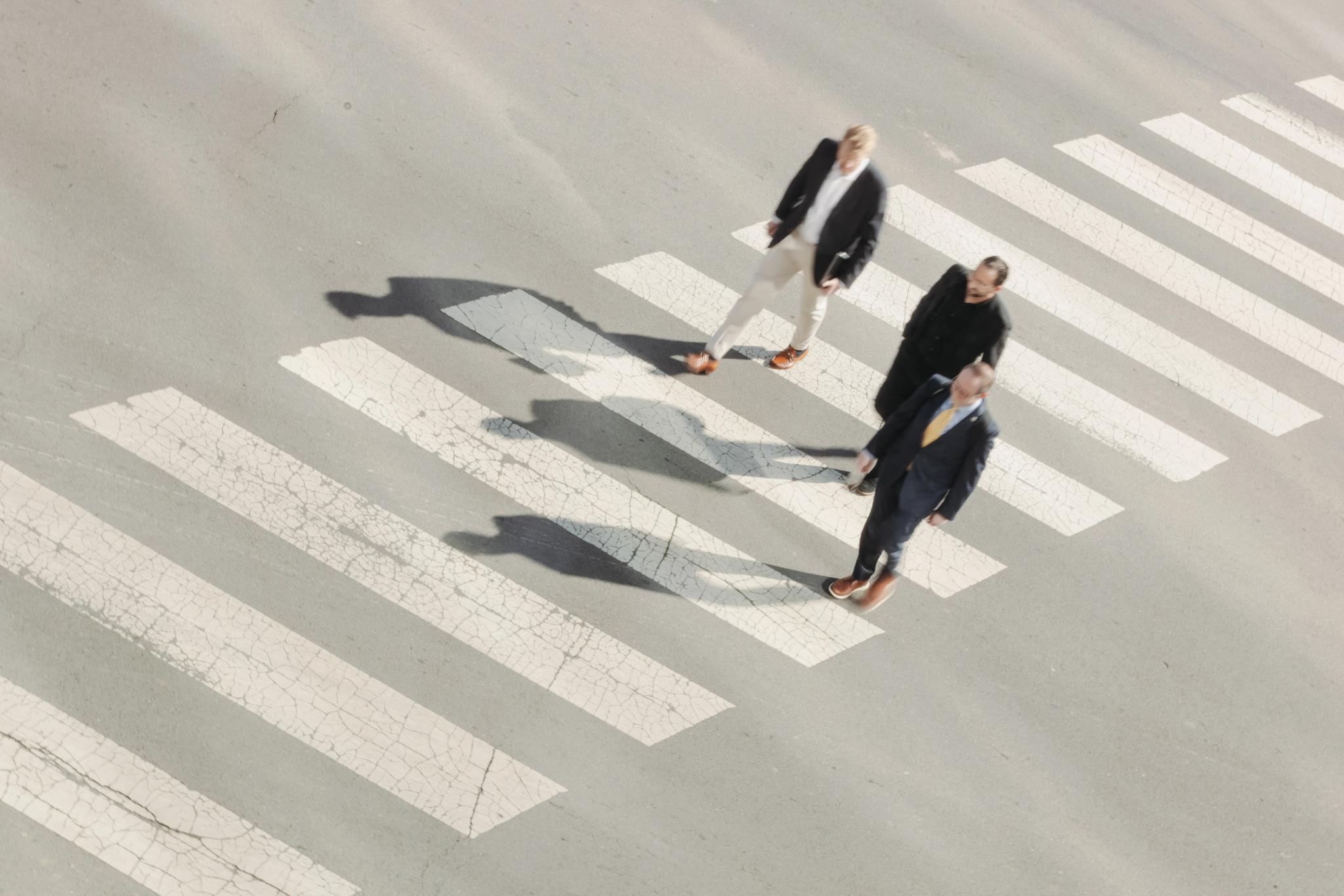 Three financial professionals crossing a street