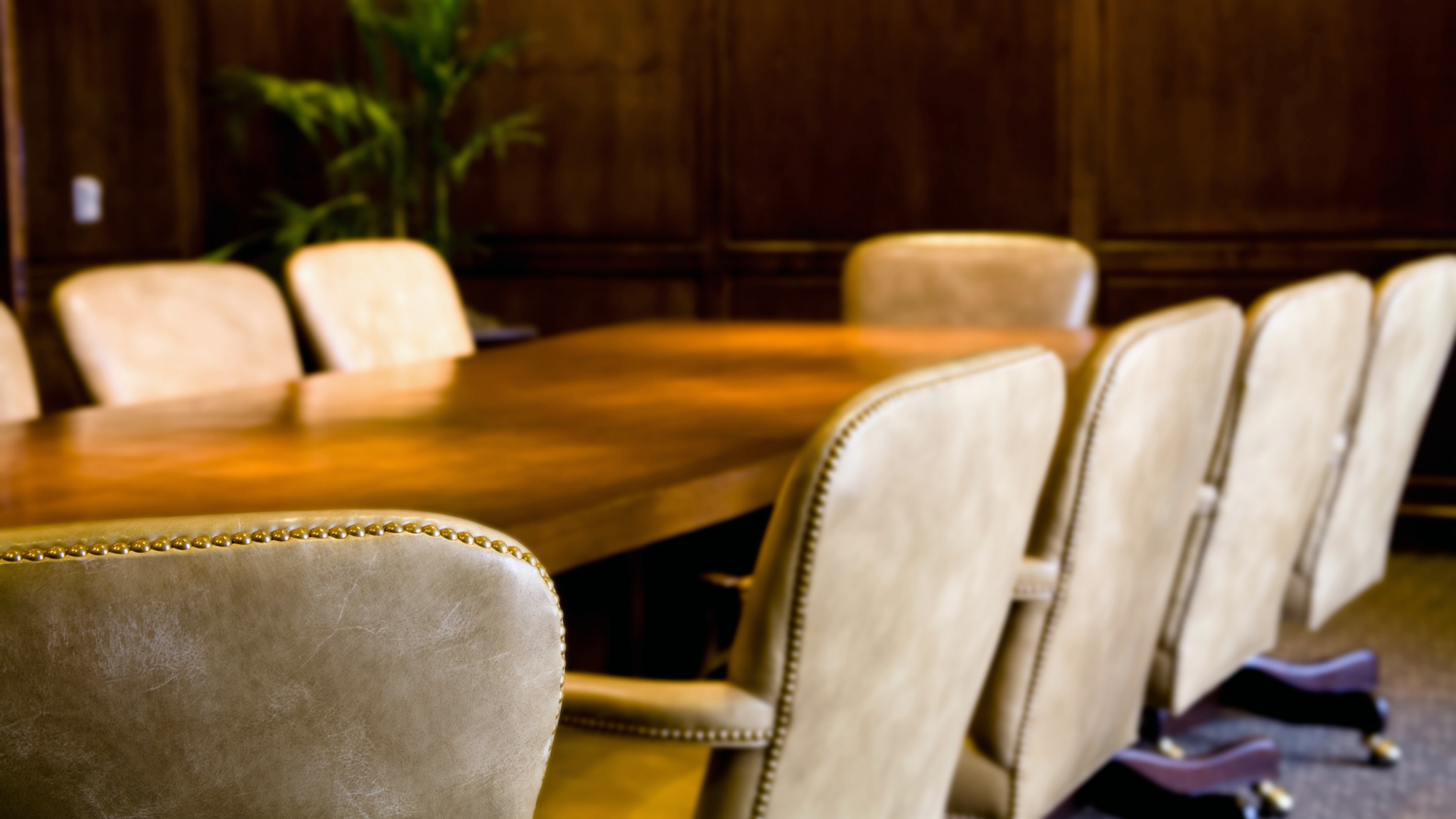 Chairs surrounding a large wooden table. 