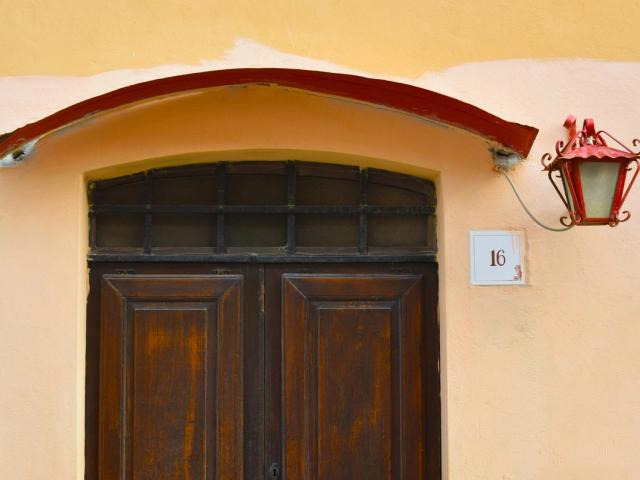 Portone in legno ad arco di una casa con applique accanto
