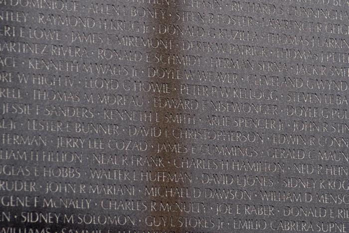 The Washington Monument reflected in the polished black granite wall of the Vietnam Veterans Memorial.