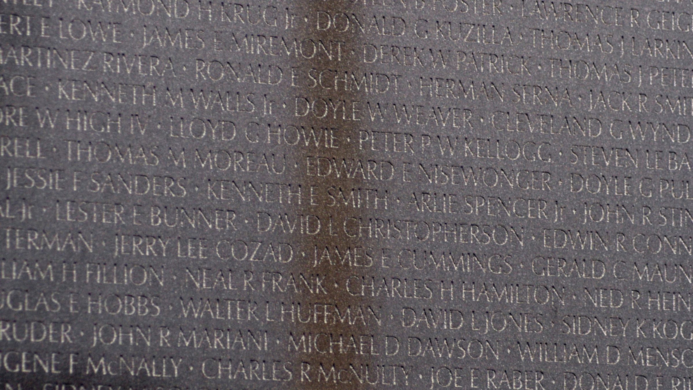 The Washington Monument reflected in the polished black granite wall of the Vietnam Veterans Memorial.