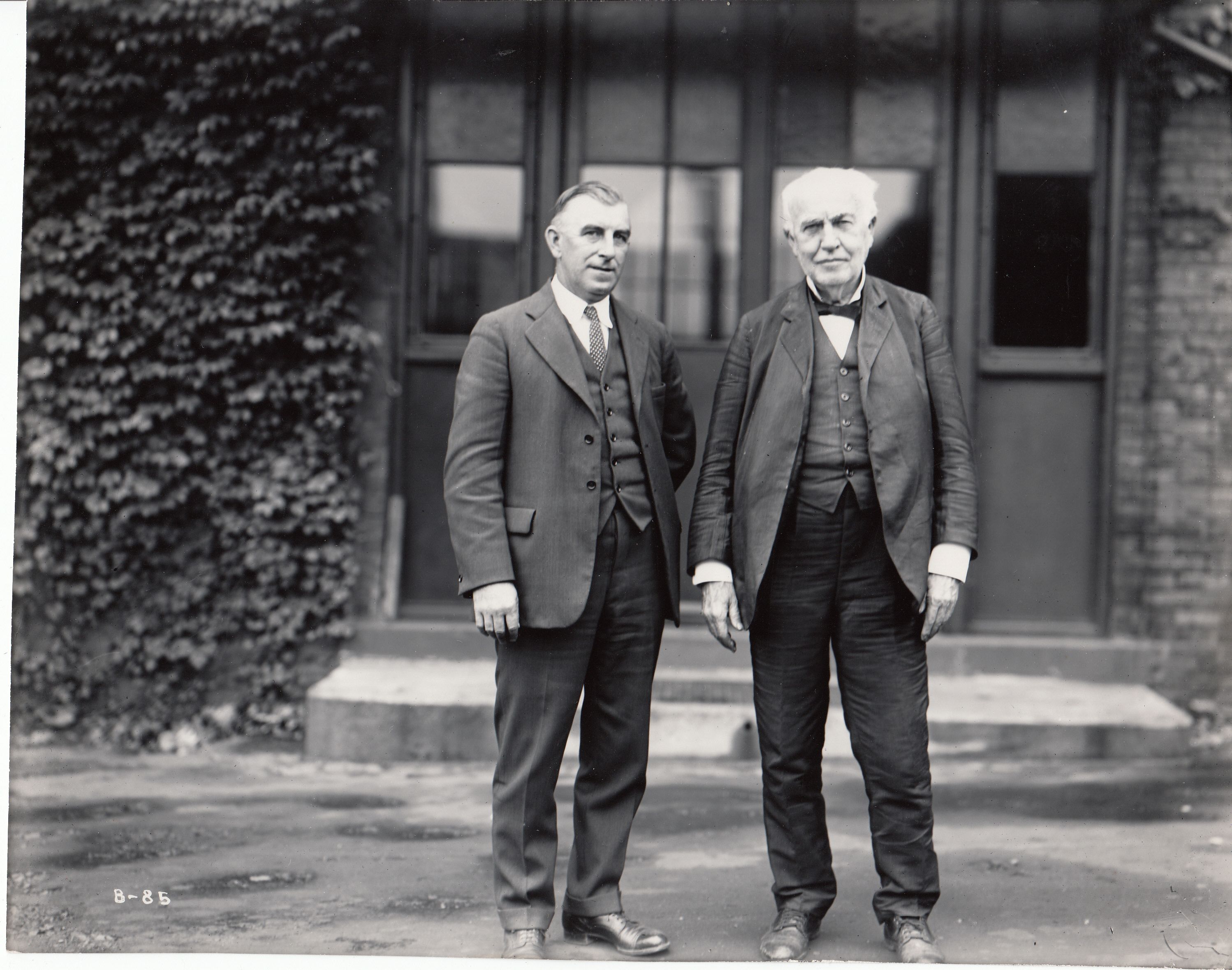 Thomas Edison standing with a visitor in front of Building 5 at his West Orange laboratory.