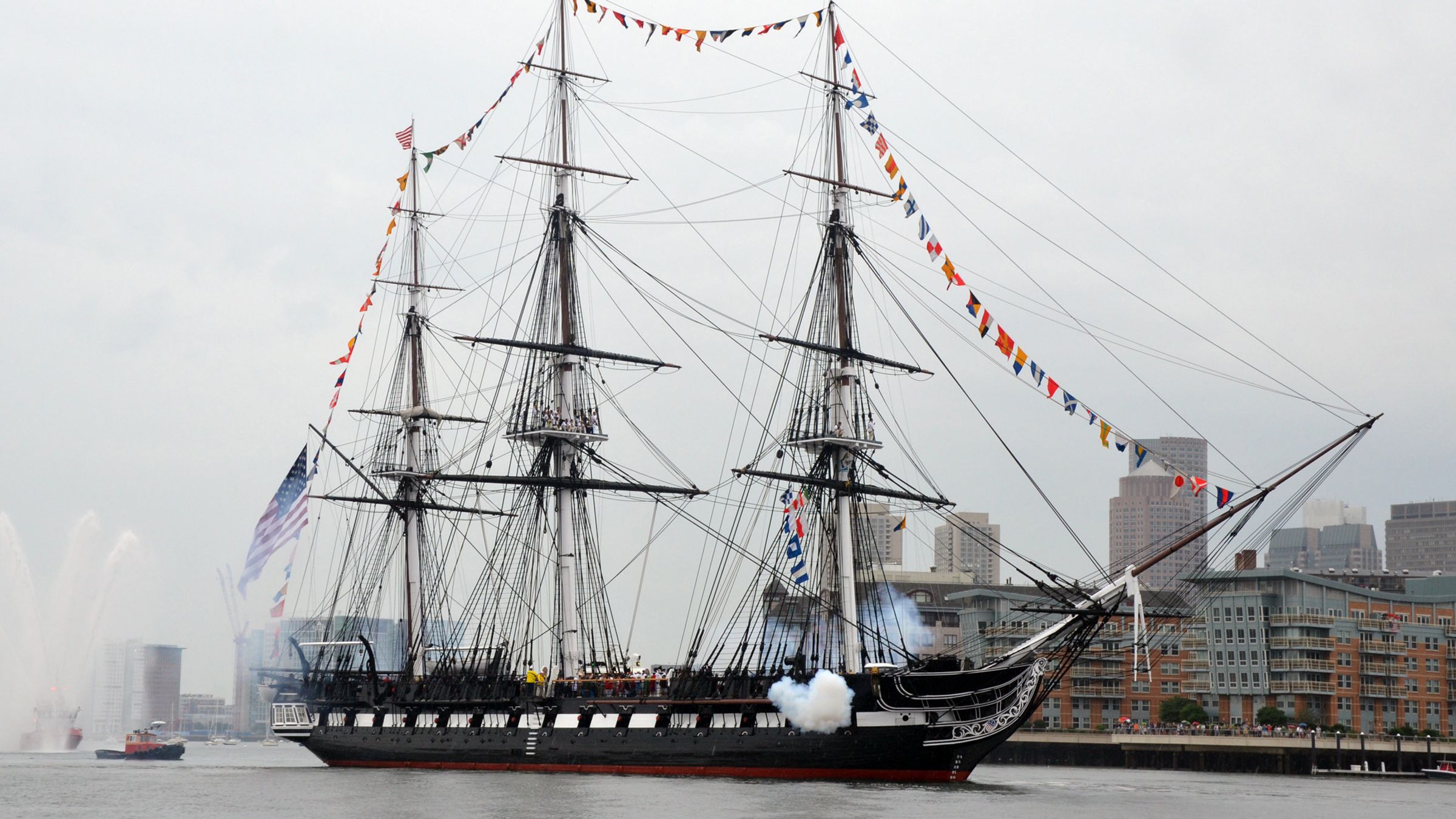 USS Constitution firing a cannon salute in Boston Harbor.