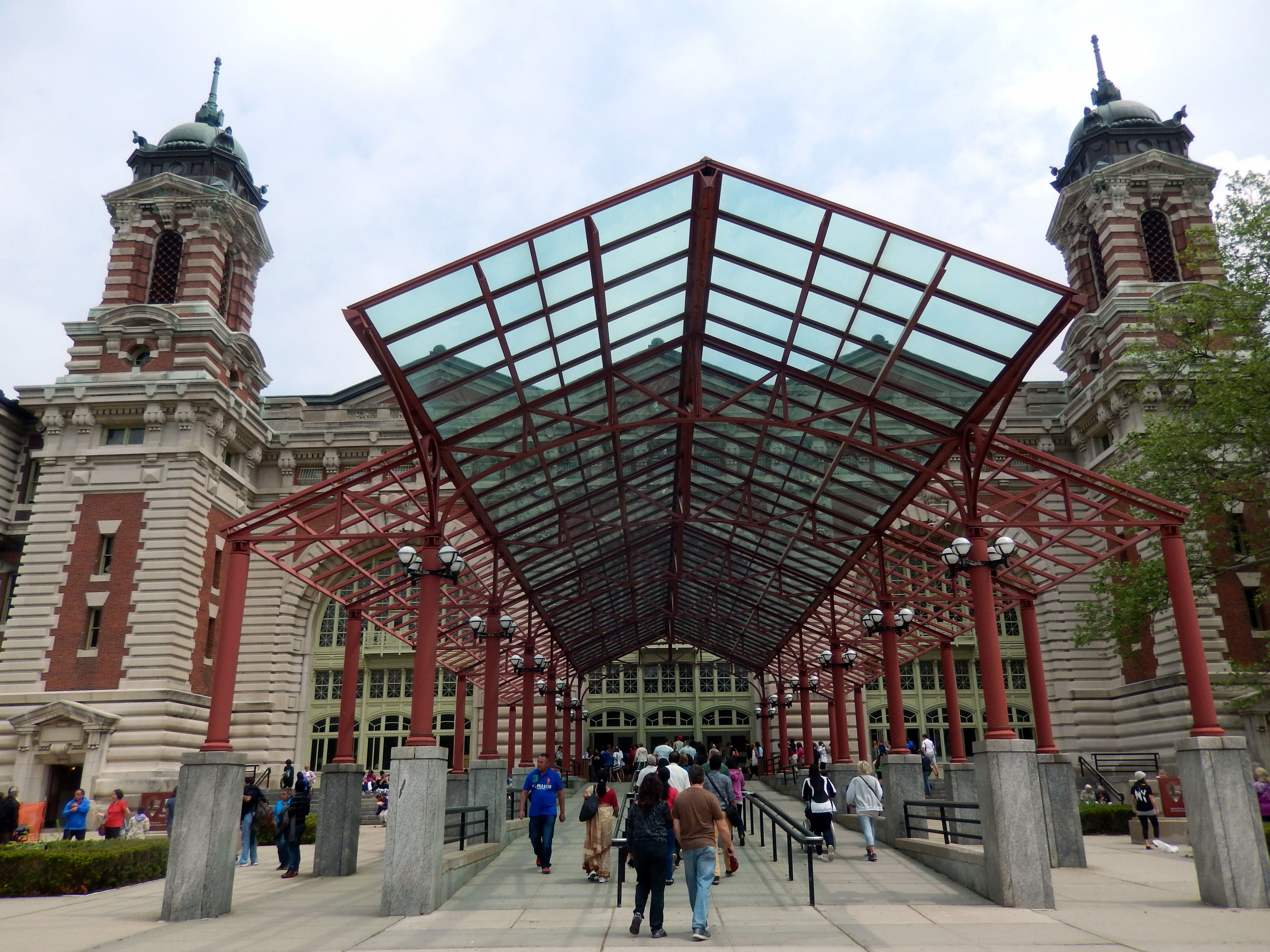 The main immigration building on Ellis Island, its red-brick towers and copper domes seen across the front lawn.