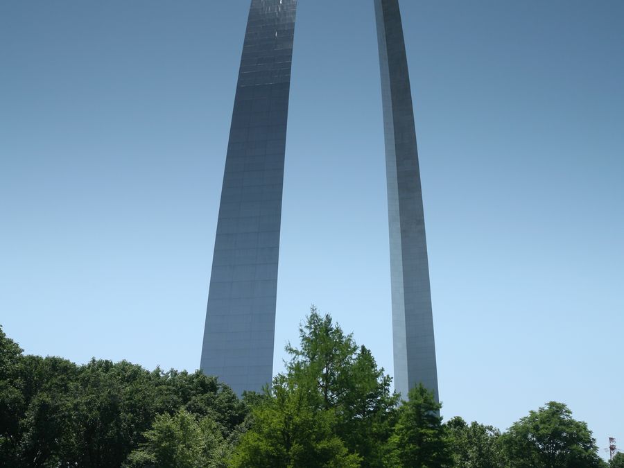 The stainless-steel Gateway Arch reflected in water.