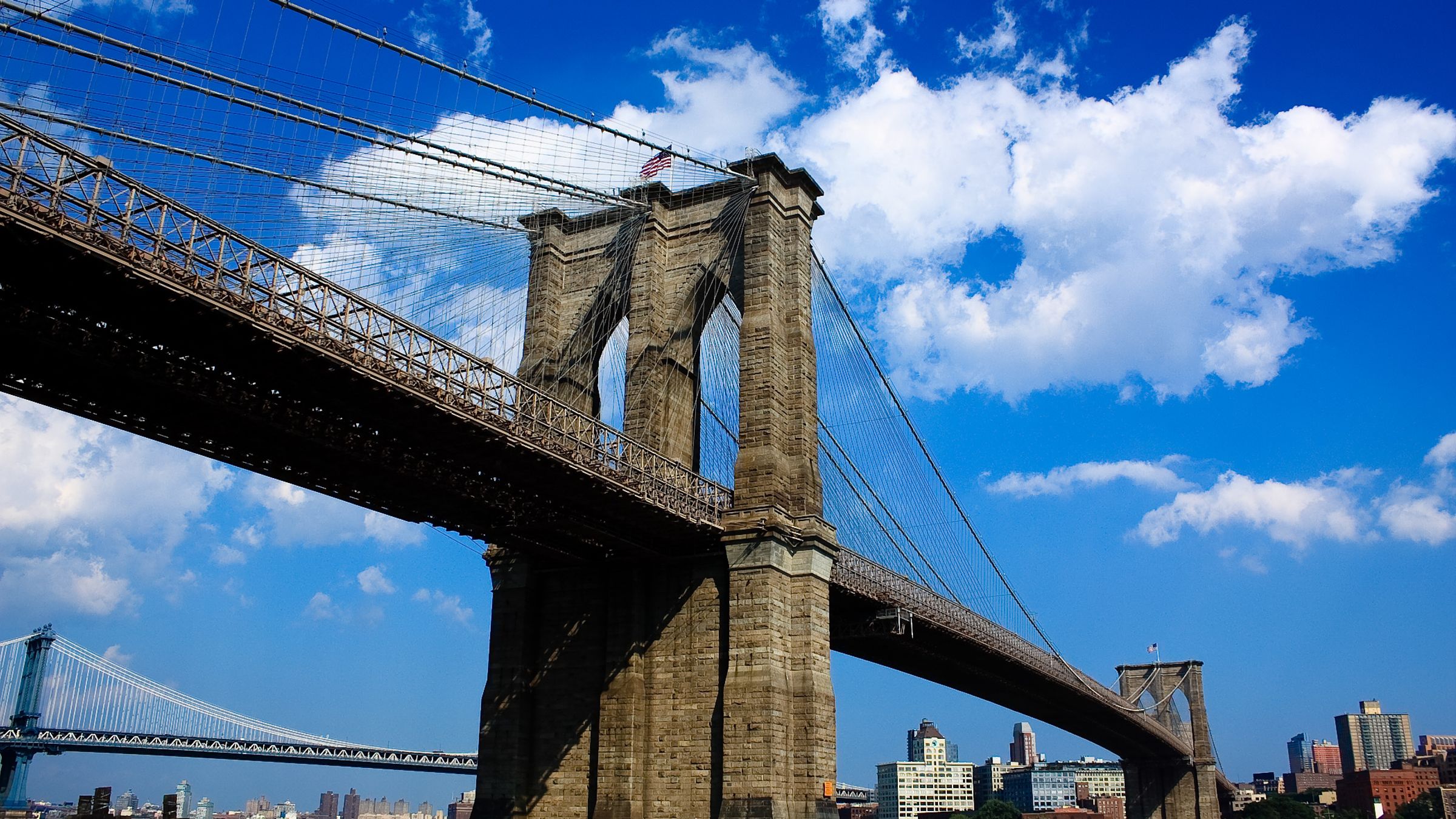 The Brooklyn Bridge with the Manhattan skyline behind it.