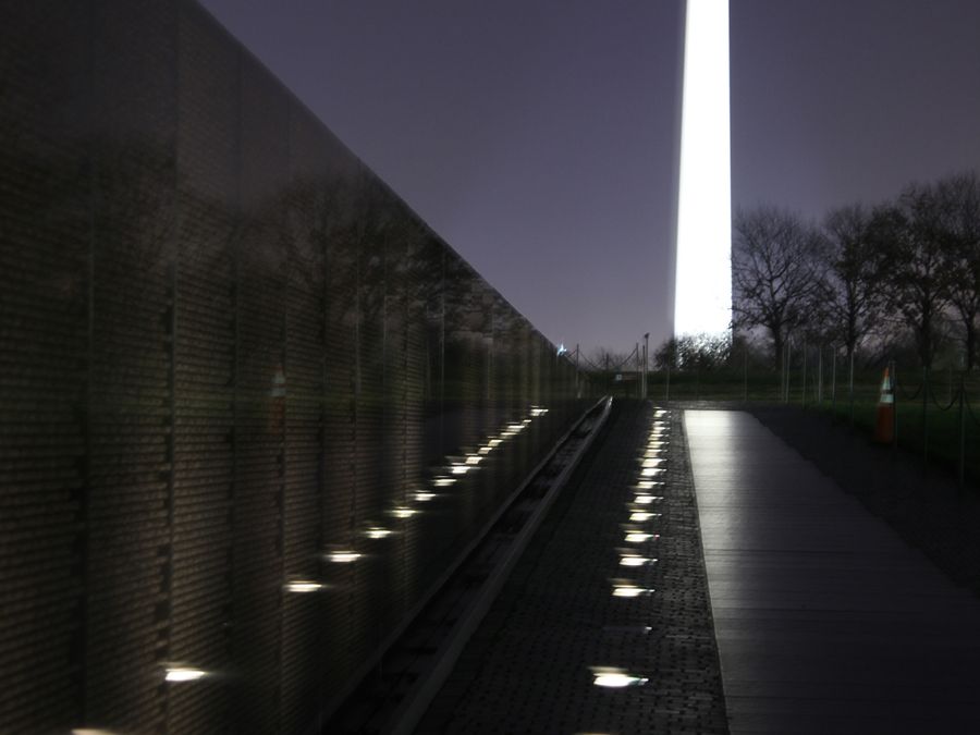 Visitors reading names inscribed on the Vietnam Veterans Memorial wall.