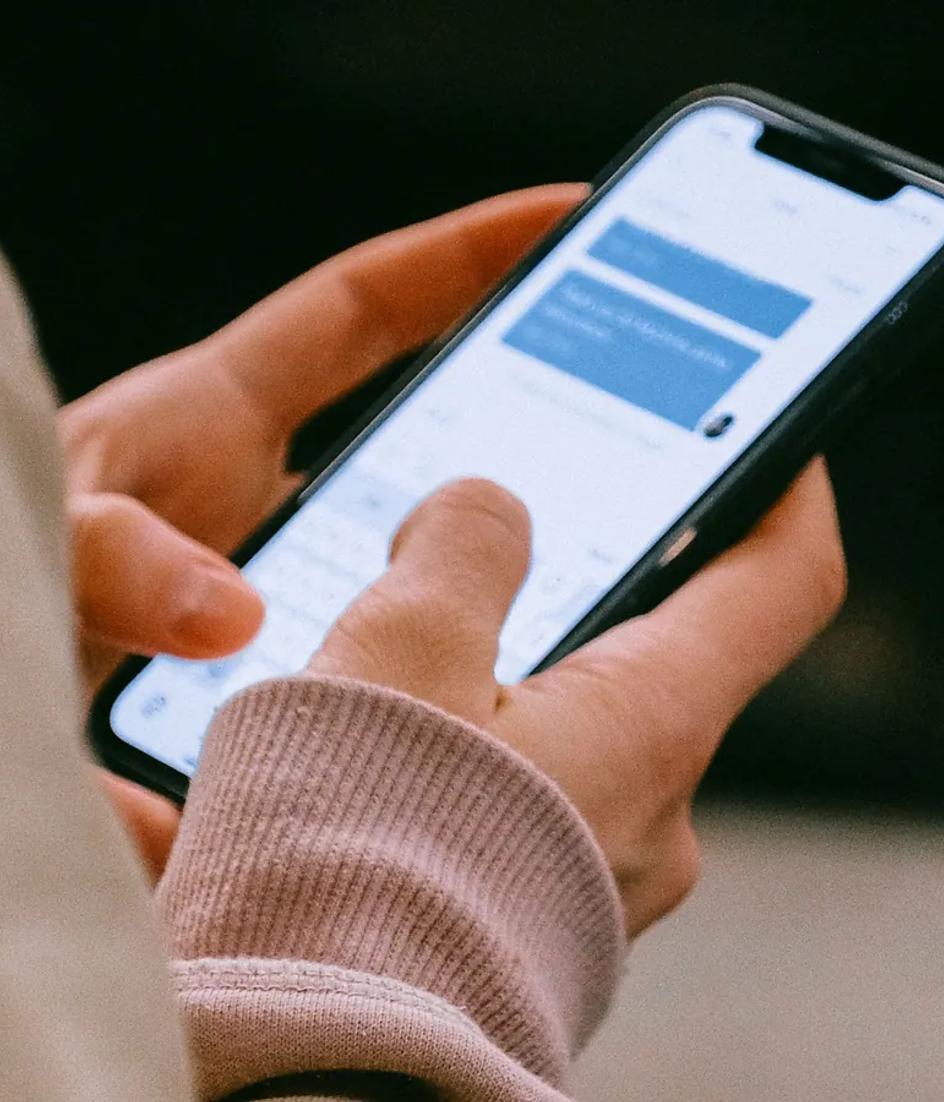 Hands holding a smartphone, the device that parses and executes the 632 KB of JavaScript a median mobile page shipped in 2025