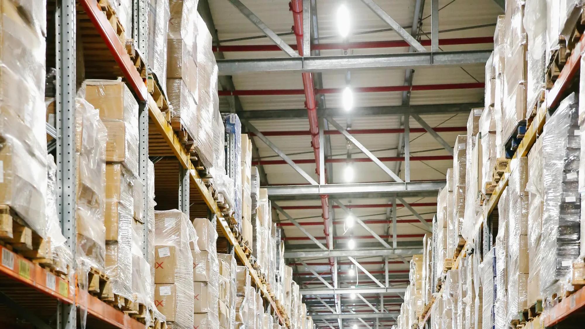 Aisles of a distribution warehouse with boxes stacked on shelving, every movement already timestamped inside the ERP