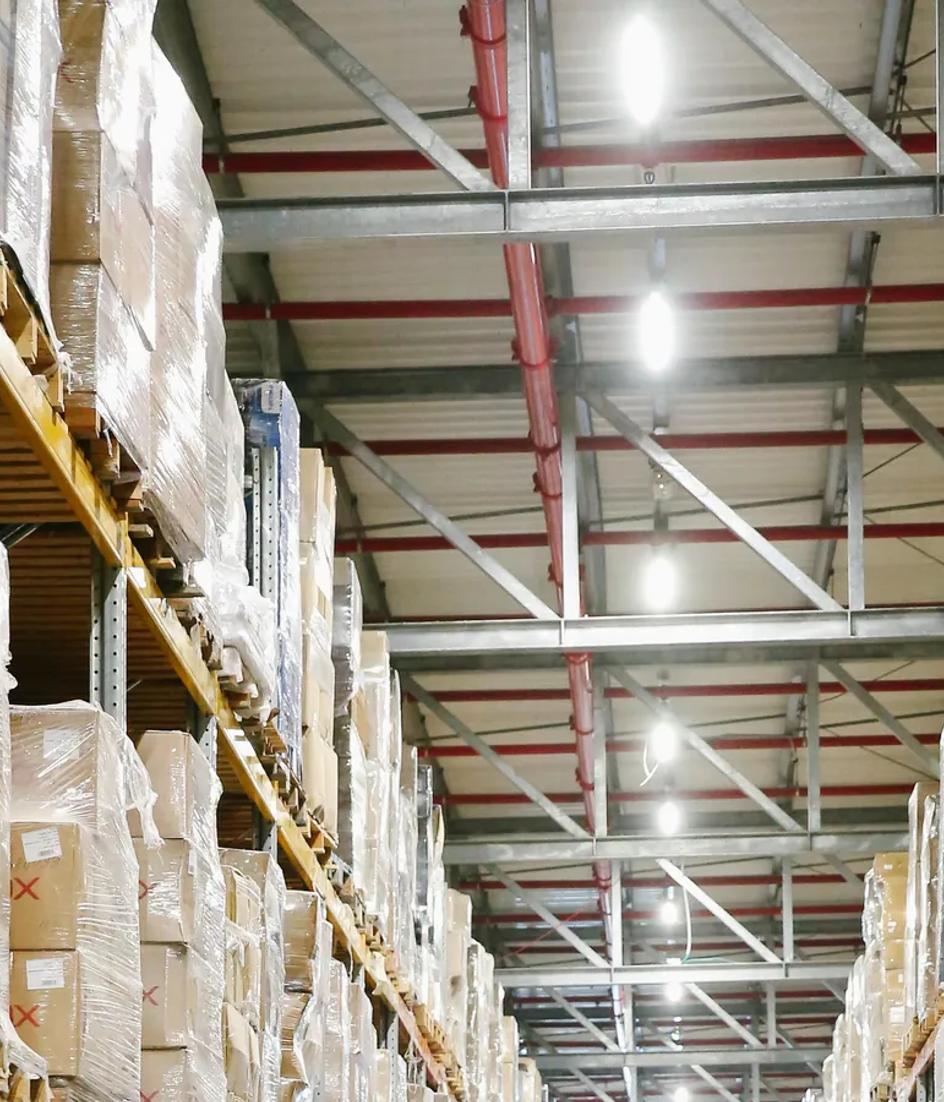 Aisles of a distribution warehouse with boxes stacked on shelving, every movement already timestamped inside the ERP