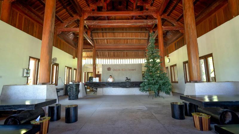 Una recepción de resort vacía bajo vigas de madera, el punto en el que una reserva se convierte en estancia