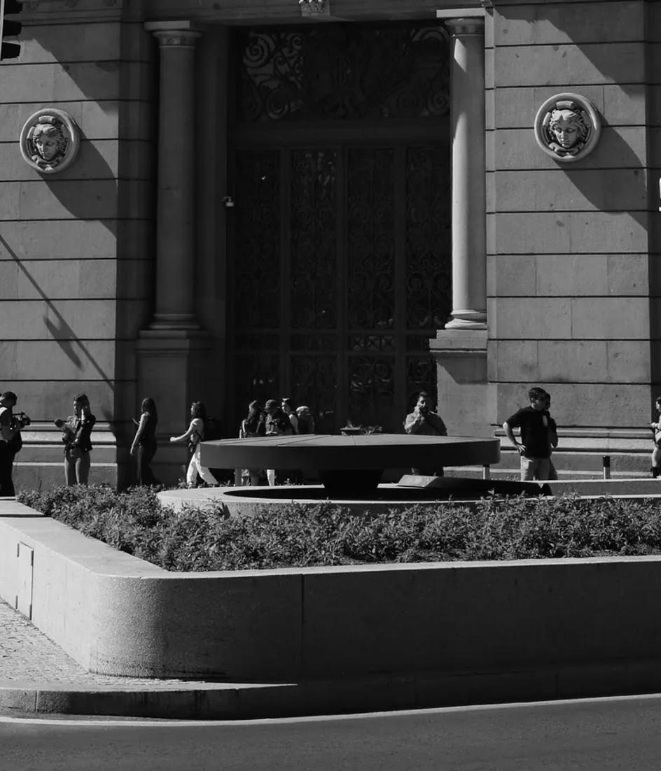 The Bank of Spain building on Calle de Alcalá in Madrid, photographed in black and white with traffic passing the facade.