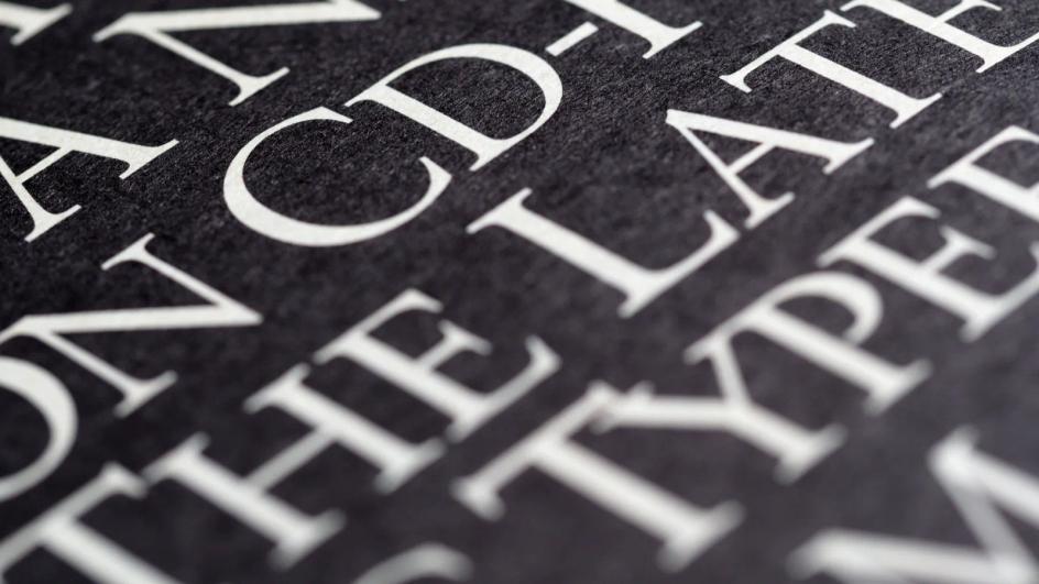 Bold white lettering printed on black paper, close enough to show how the counters hold at high contrast.