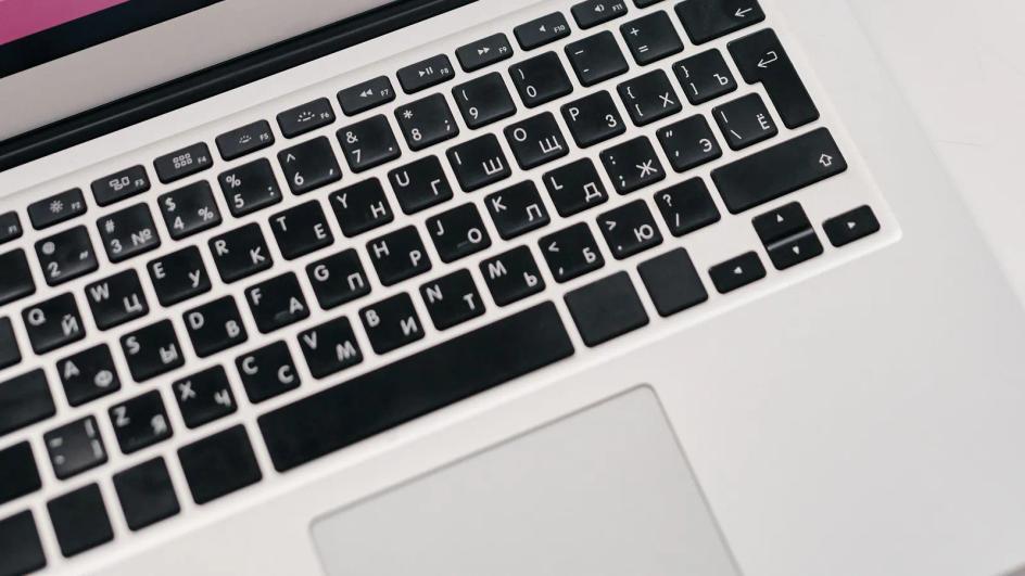 A laptop showing performance graphs on a desk beside printed reports, the same period counted twice by two sources
