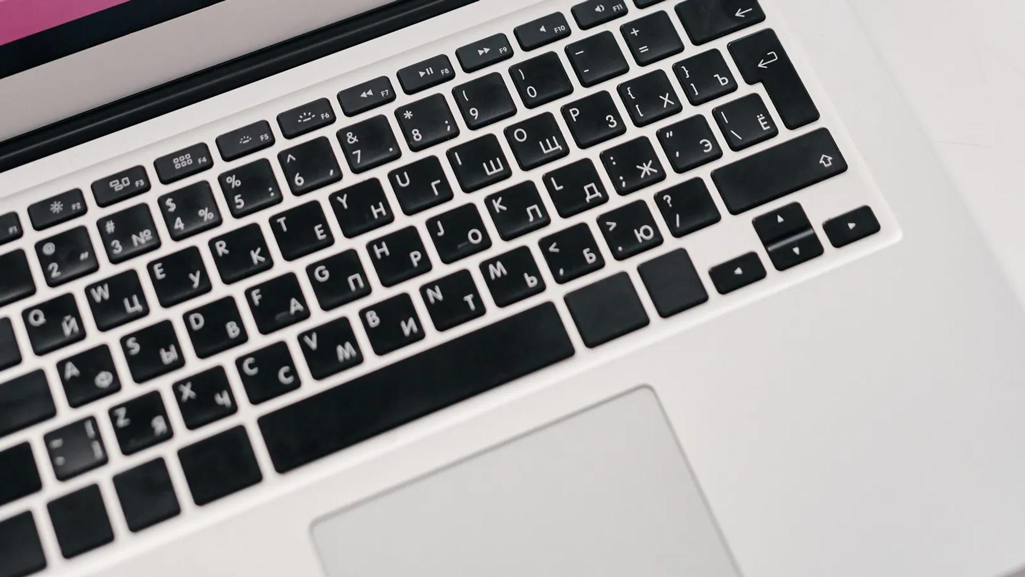 A laptop showing performance graphs on a desk beside printed reports, the same period counted twice by two sources