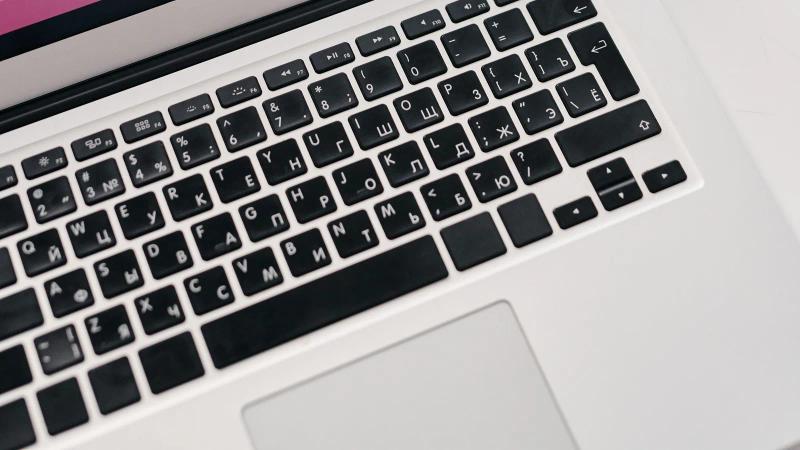 A laptop showing performance graphs on a desk beside printed reports, the same period counted twice by two sources